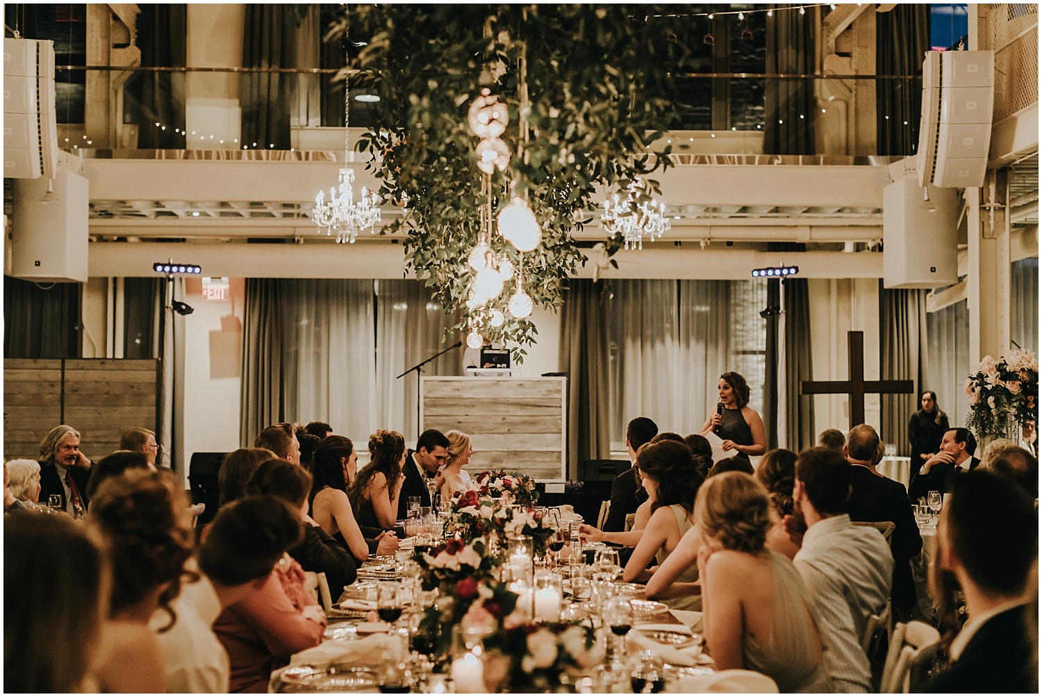 overhead greenery and lights in wedding reception