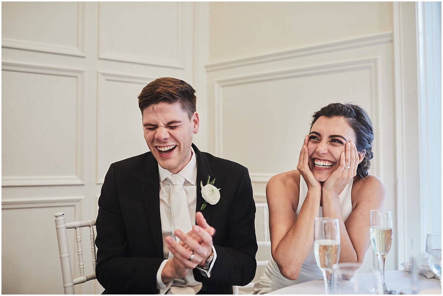 bride and groom laughing during their wedding reception 
