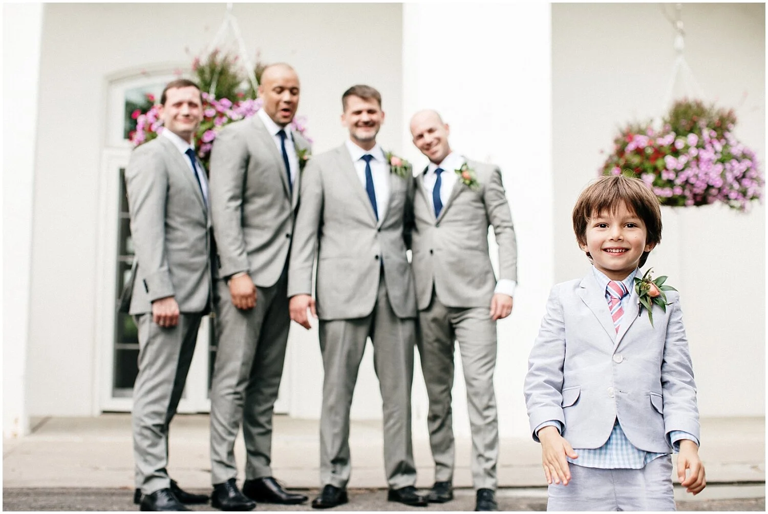 groom and groomsmen looking at the ring bearer
