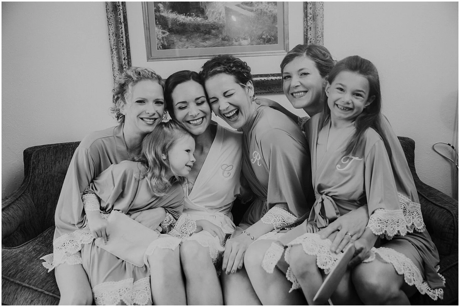 bride laughing with her bridesmaids and flower girl