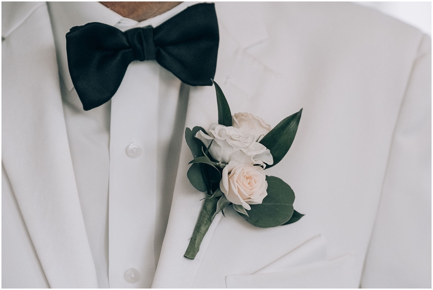  groom looks with a white suit and boutonniere 