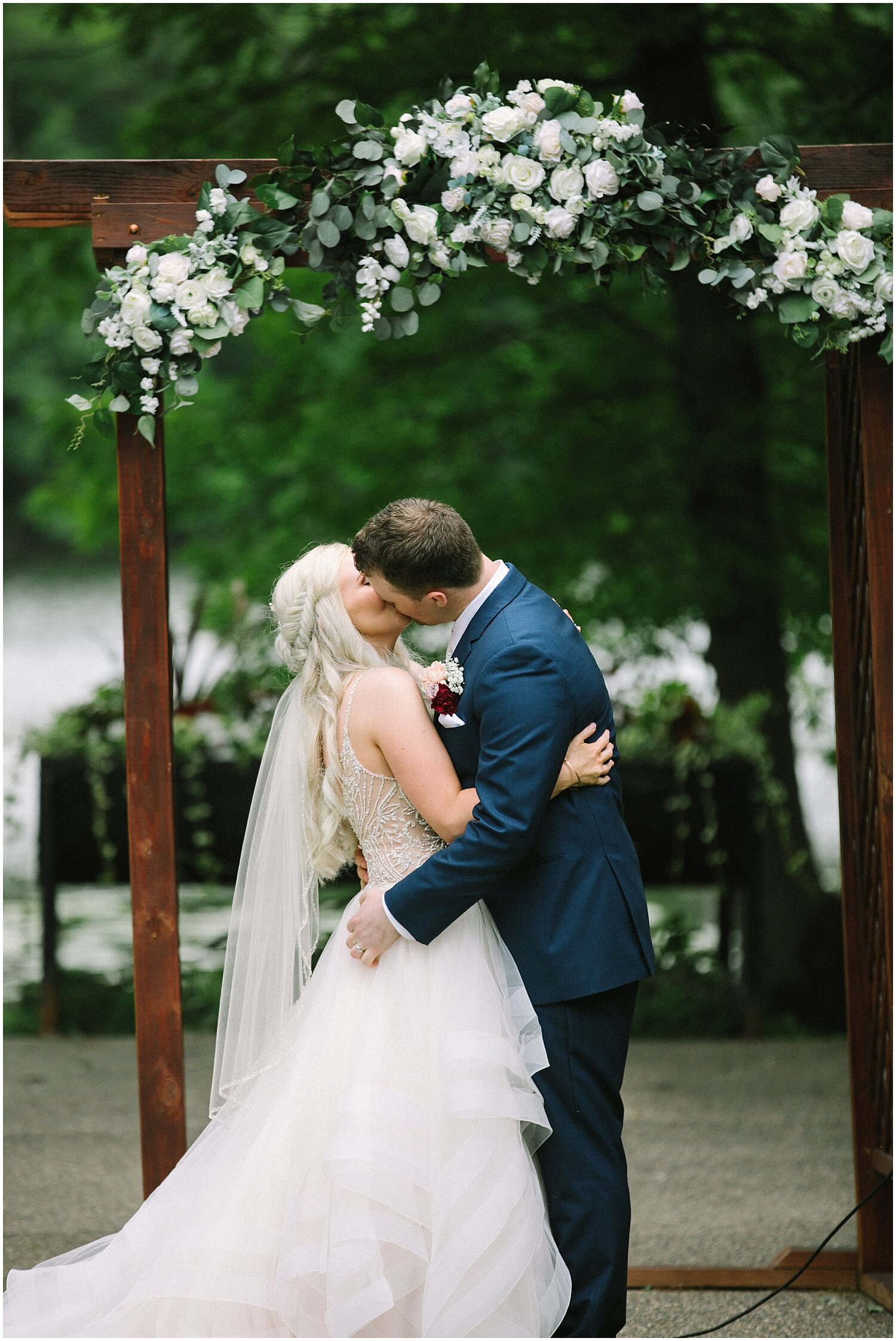  bride and groom kiss as they say I do at their outdoor wedding ceremony 