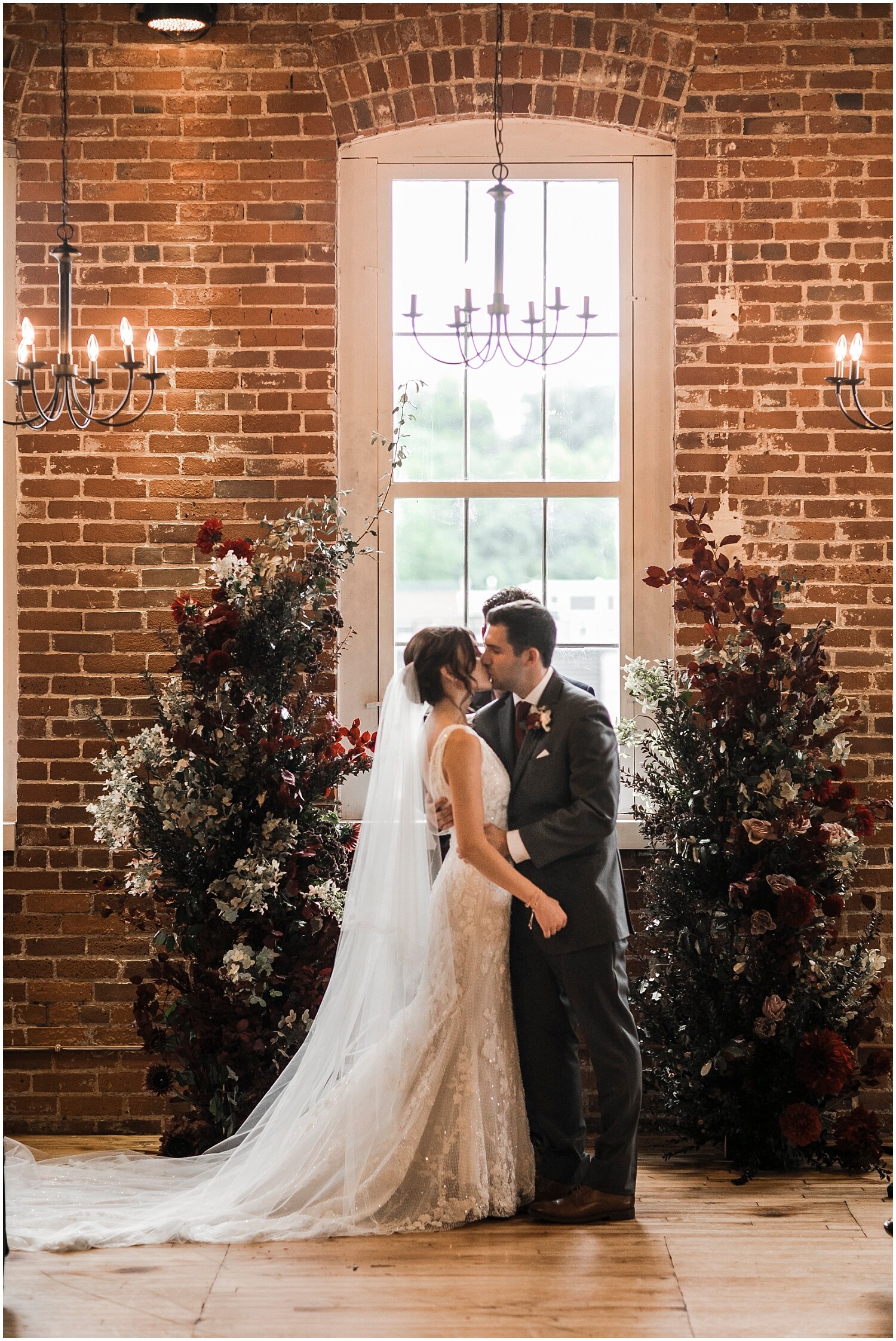  bride and groom kiss at their industrial and fall themed wedding 