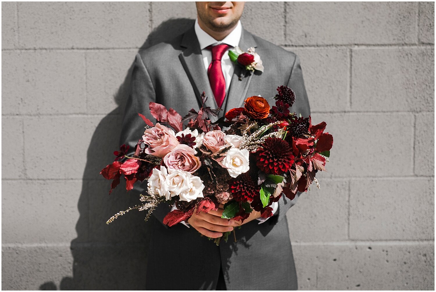  groom holding the bride’s wedding bouquet 