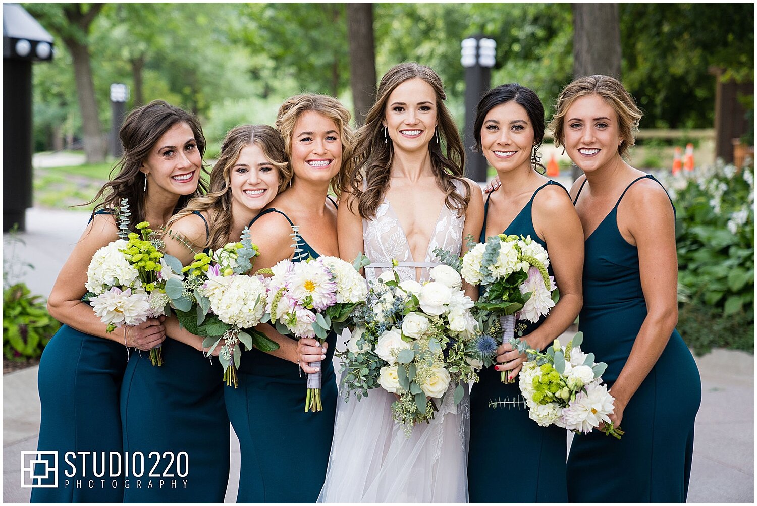  bride and bridesmaids holding their white bridal bouquets 