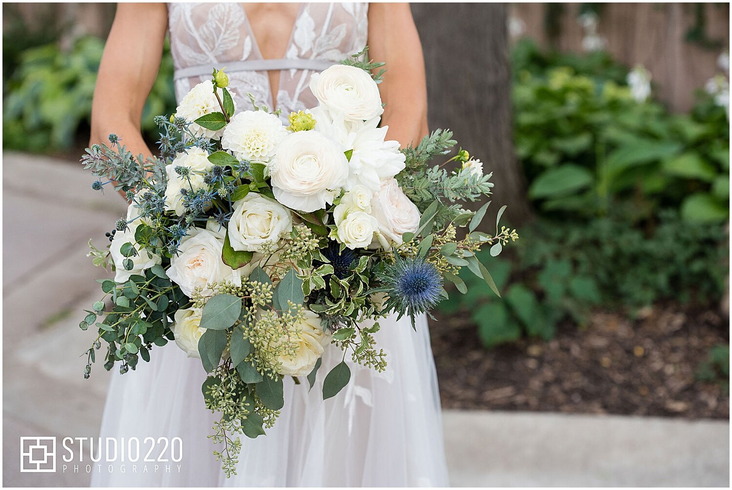  bride holding her white and greenery wedding bouquet 