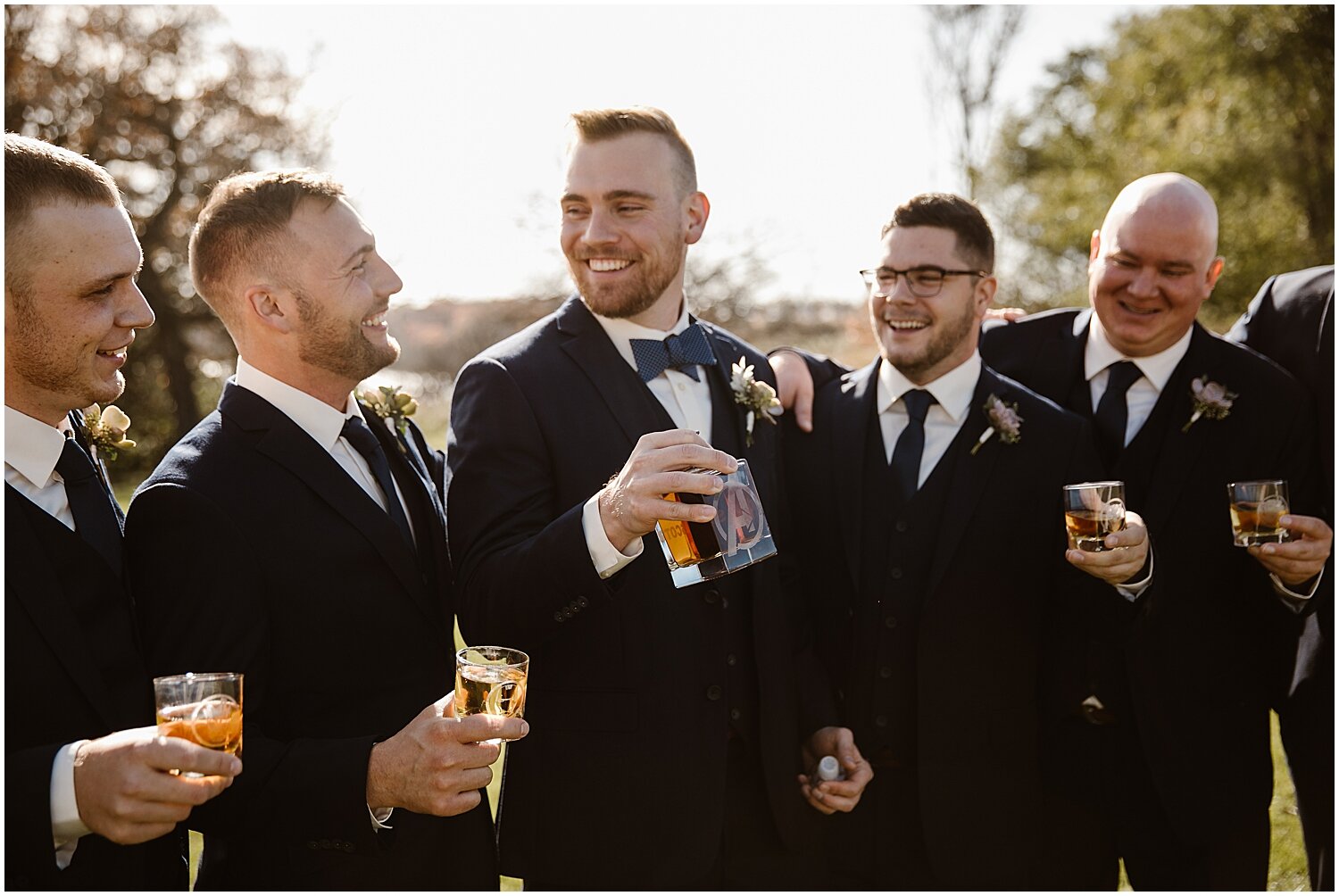  groom and groomsmen drinking before the wedding ceremony 