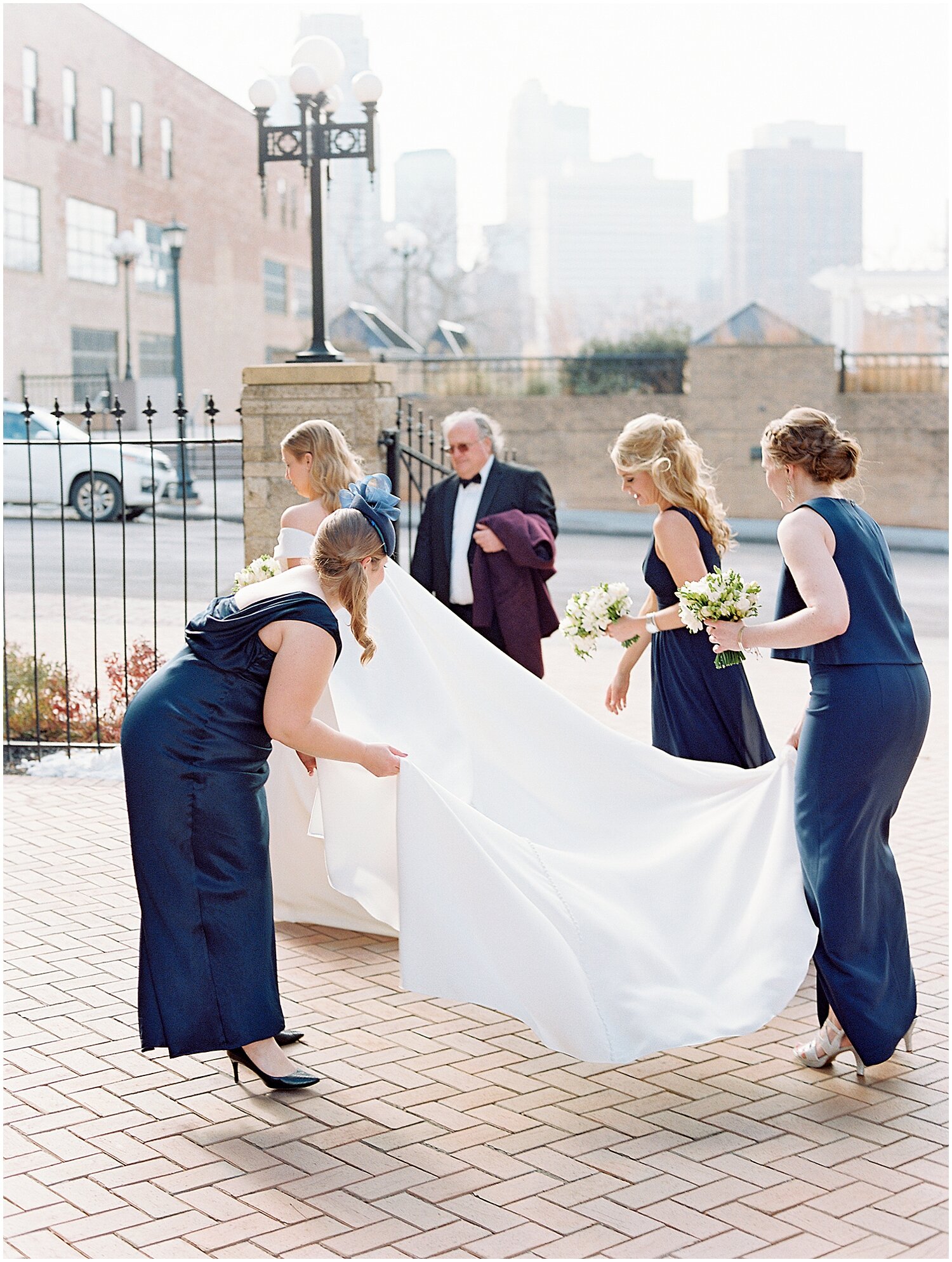  bridesmaids helping the bride with her wedding dress 