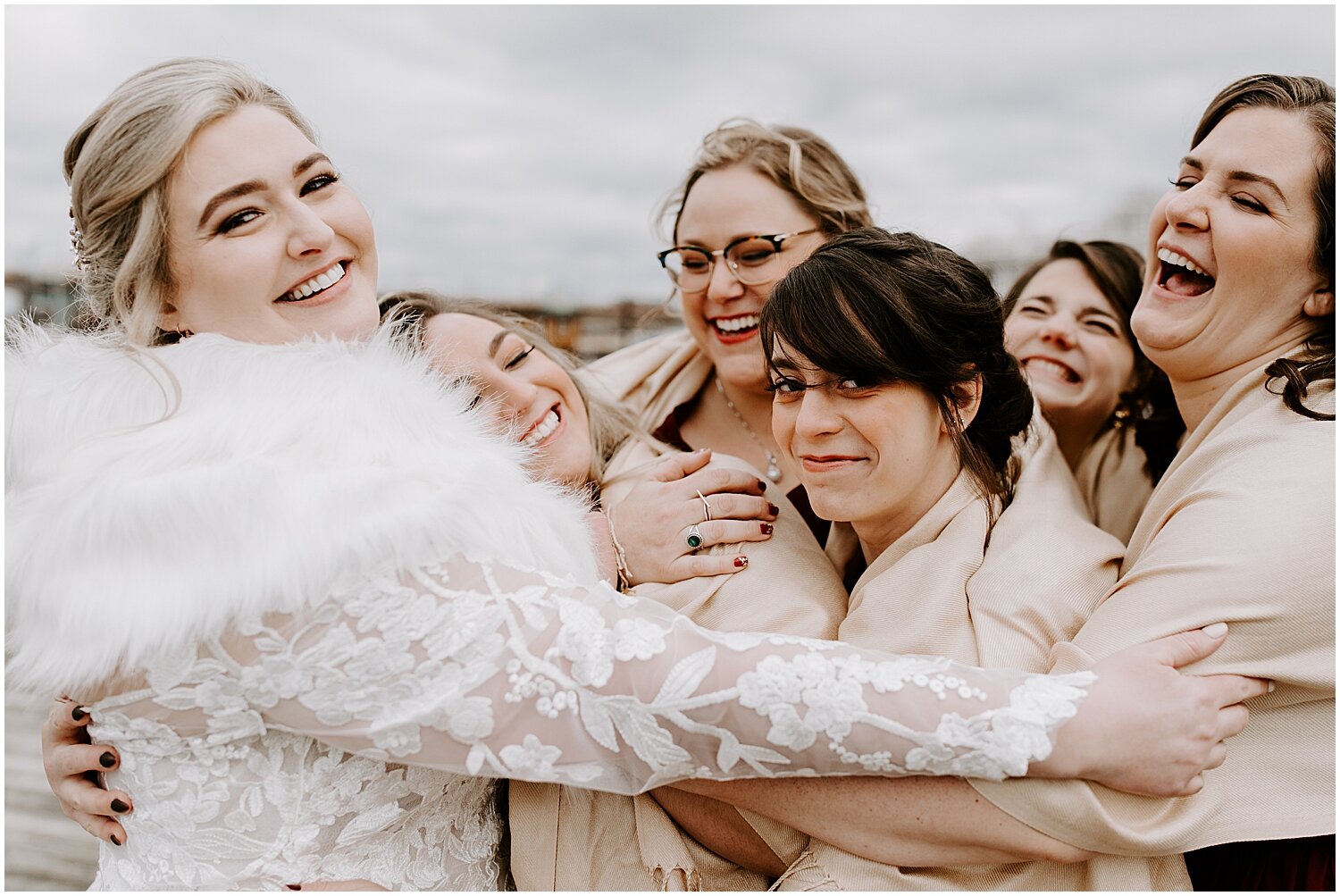  bride and bridesmaids cuddled up for a group hug 