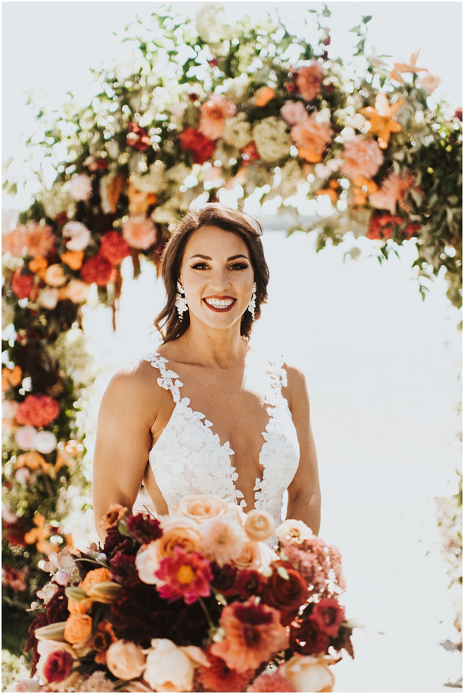  bride holding her bridal bouquet in front of the wedding arch 