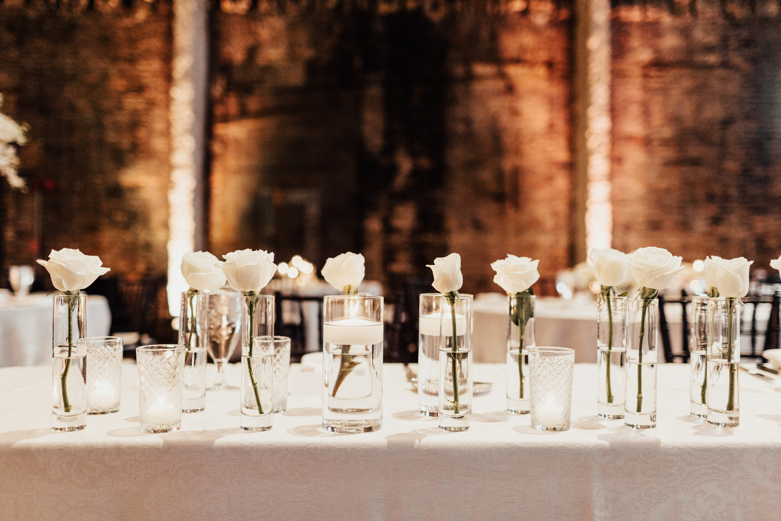  water candlelights and white roses as wedding reception decor 