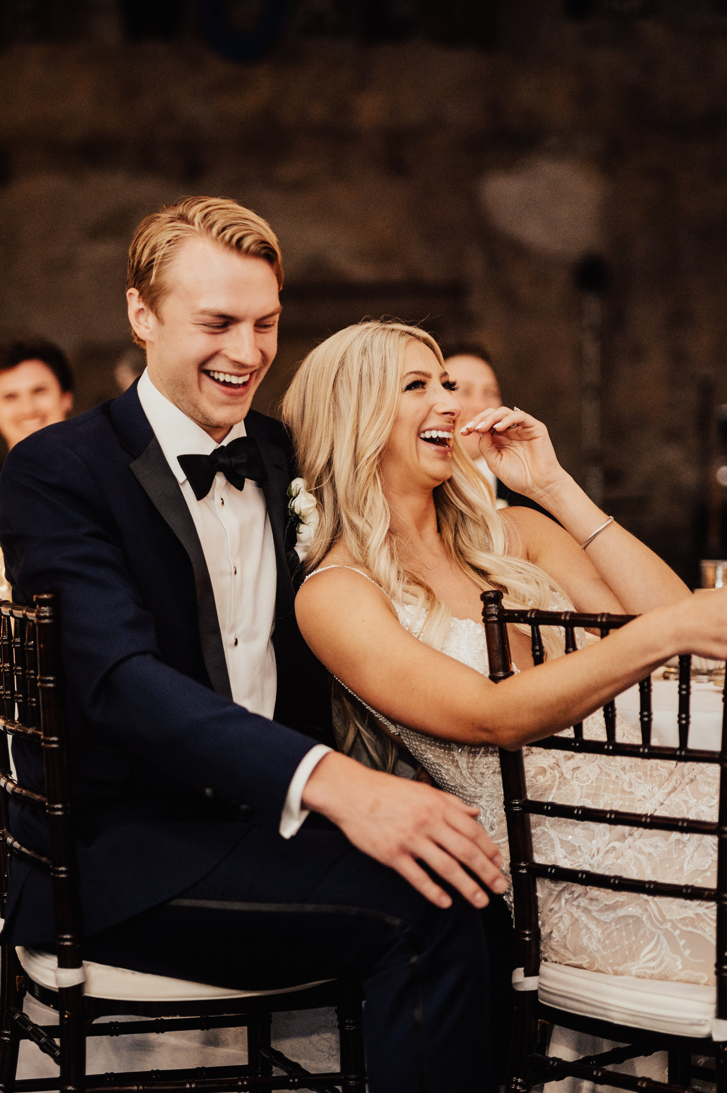  bride and groom laughing at their wedding reception   