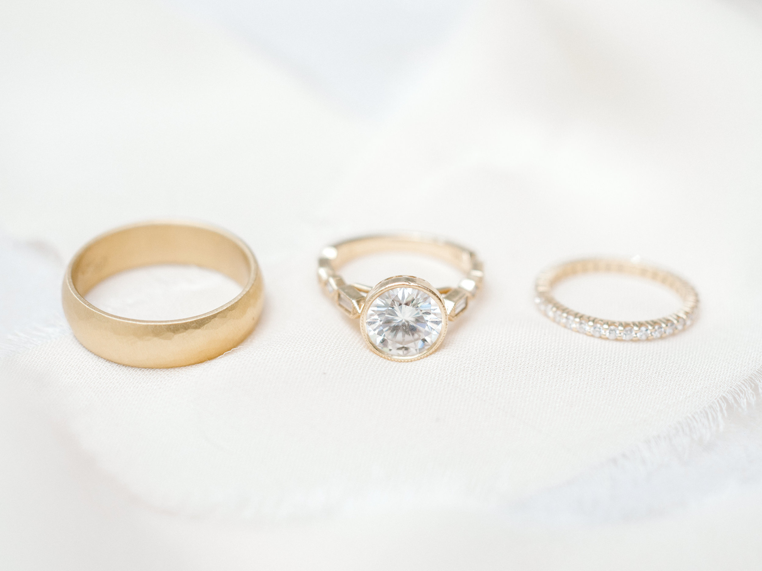 Modern gold wedding rings. Large white circular diamond engagement ring with modern gold fitting.