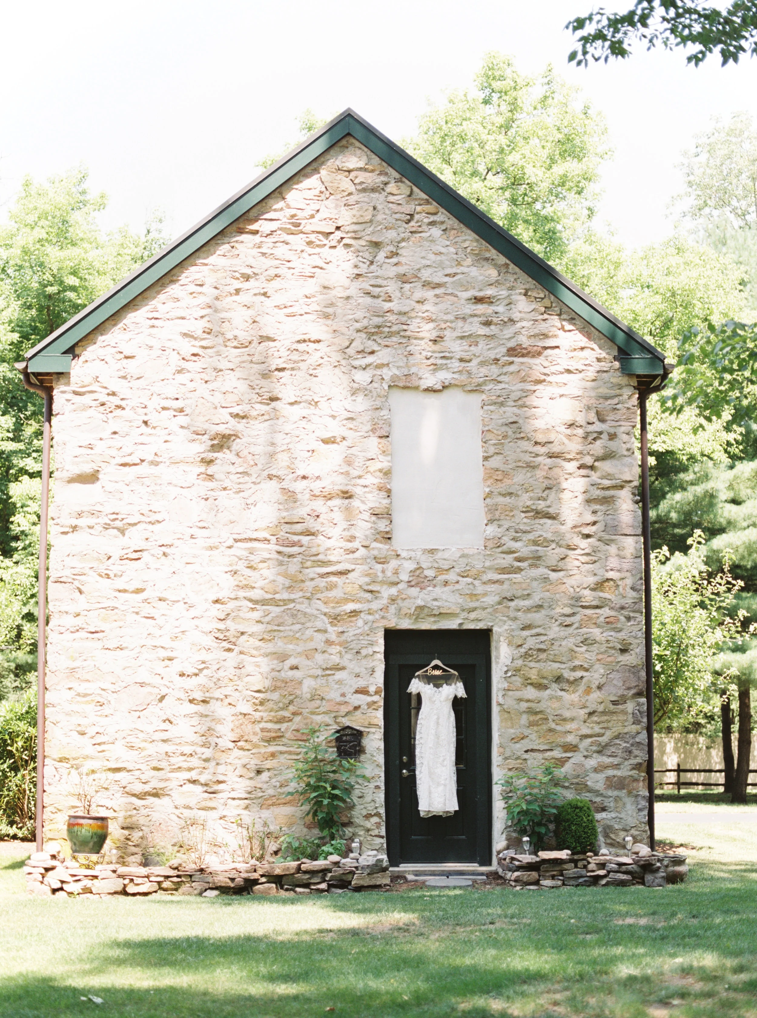 Pastoral vibes from this modern lace Lover’s Society wedding dress hanging on this old stone building. A summer dream.