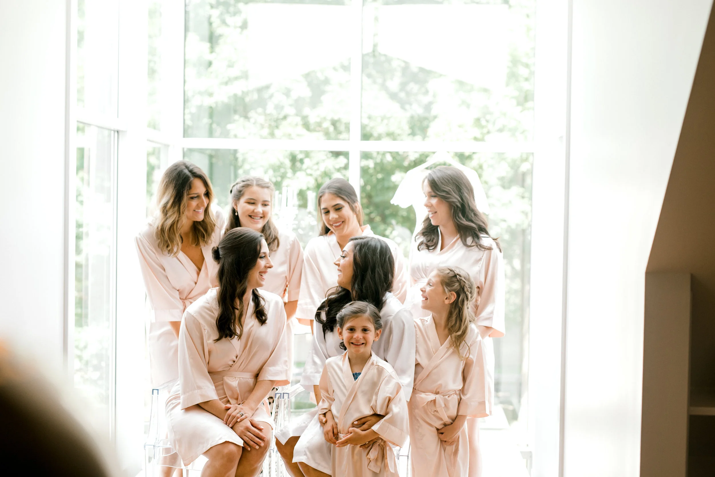 All the girls getting ready in their pink robes before a colorful and modern wedding day at Hotel du Village.