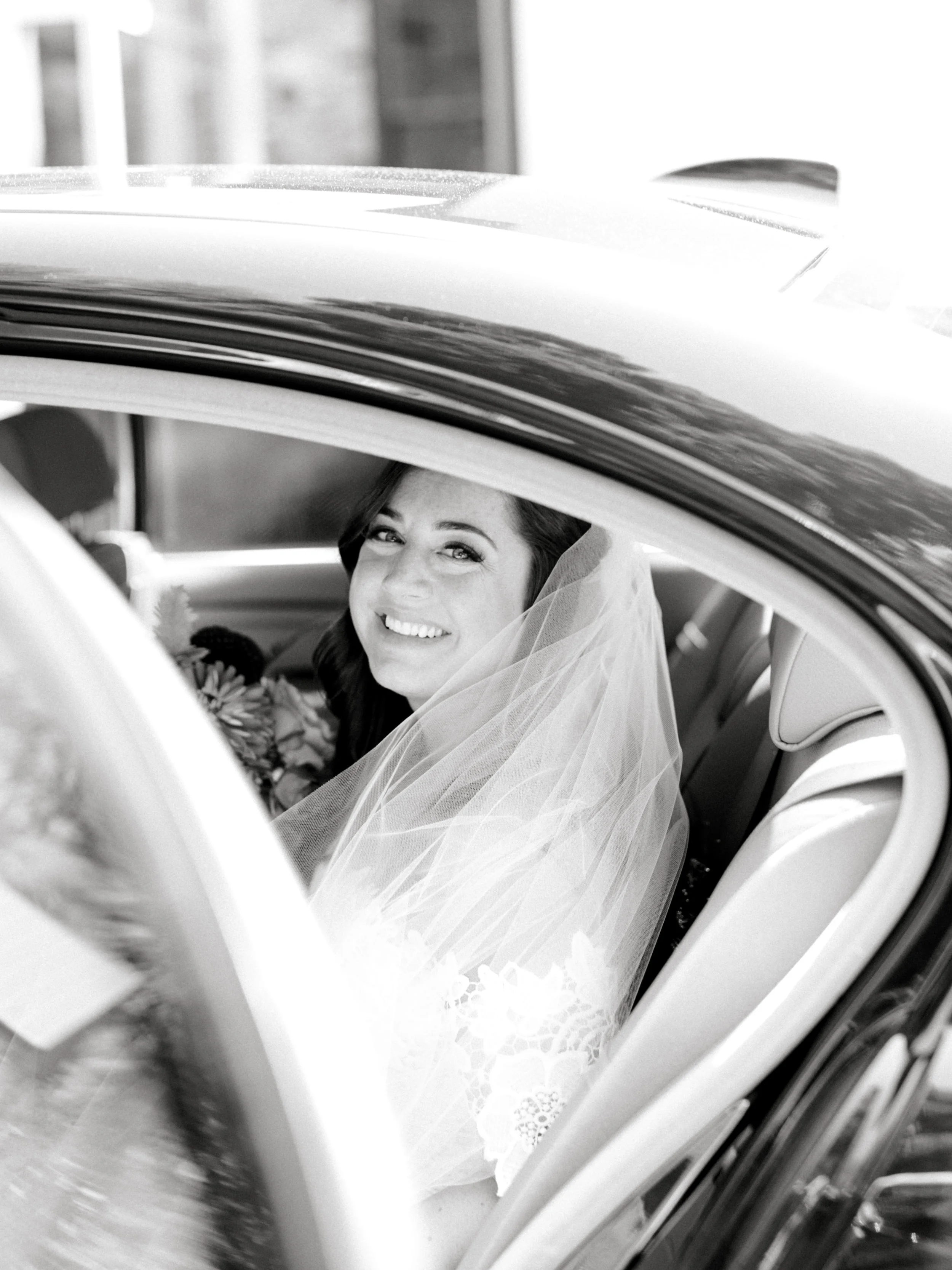 Lindsey is all smiles as she gets in the car ready to head off to her modern summer wedding at Hotel du Village.