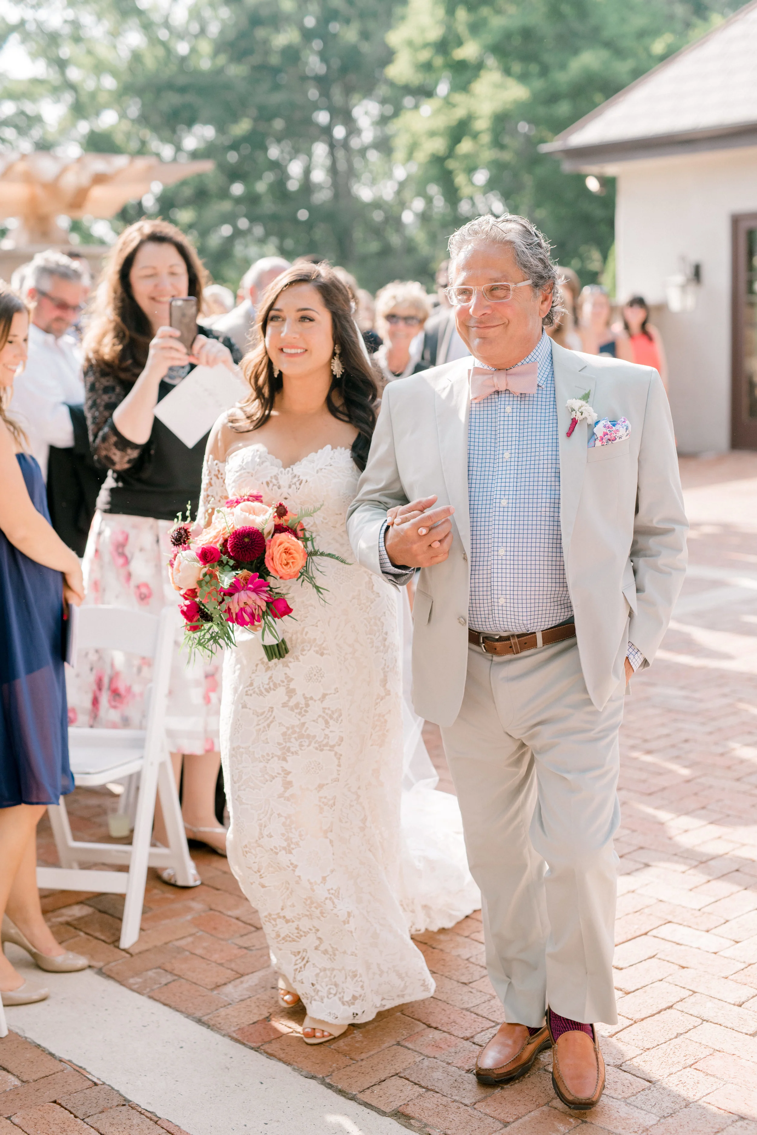 An emotional moment as Lindsey walks down the aisle with her dad for her bright and modern summer wedding day at Hotel du Village.
