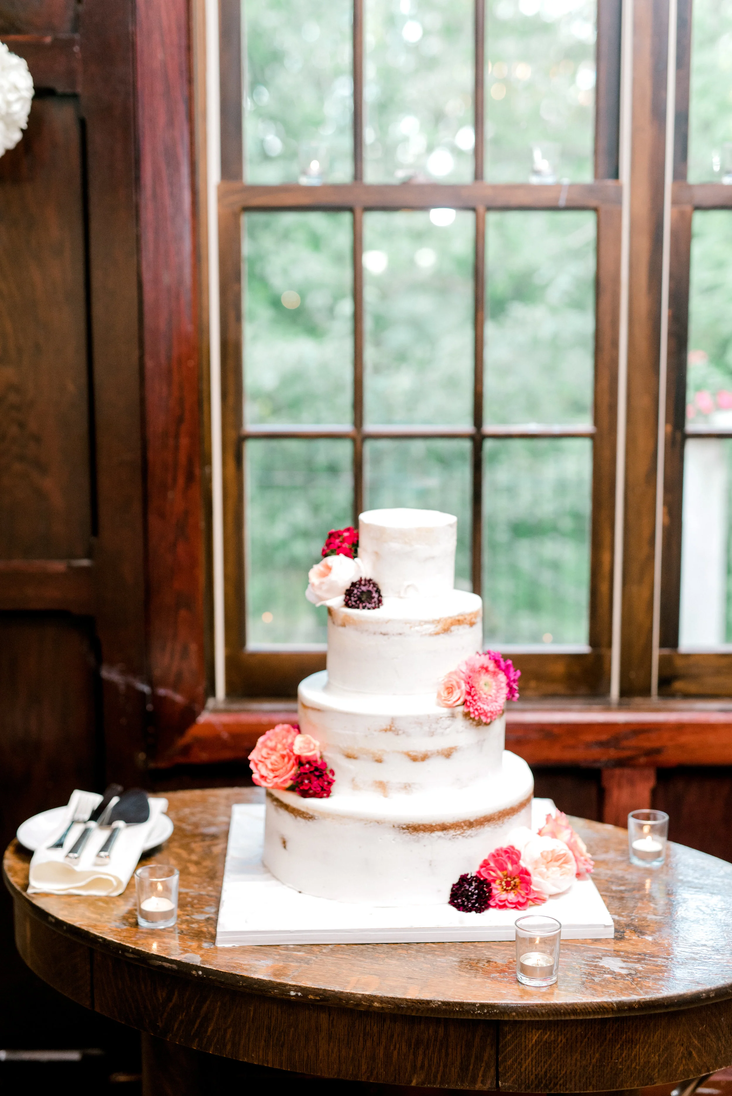 This simple naked cake with pops of pink flowers at Hotel du Village has us dreaming of modern summer weddings.
