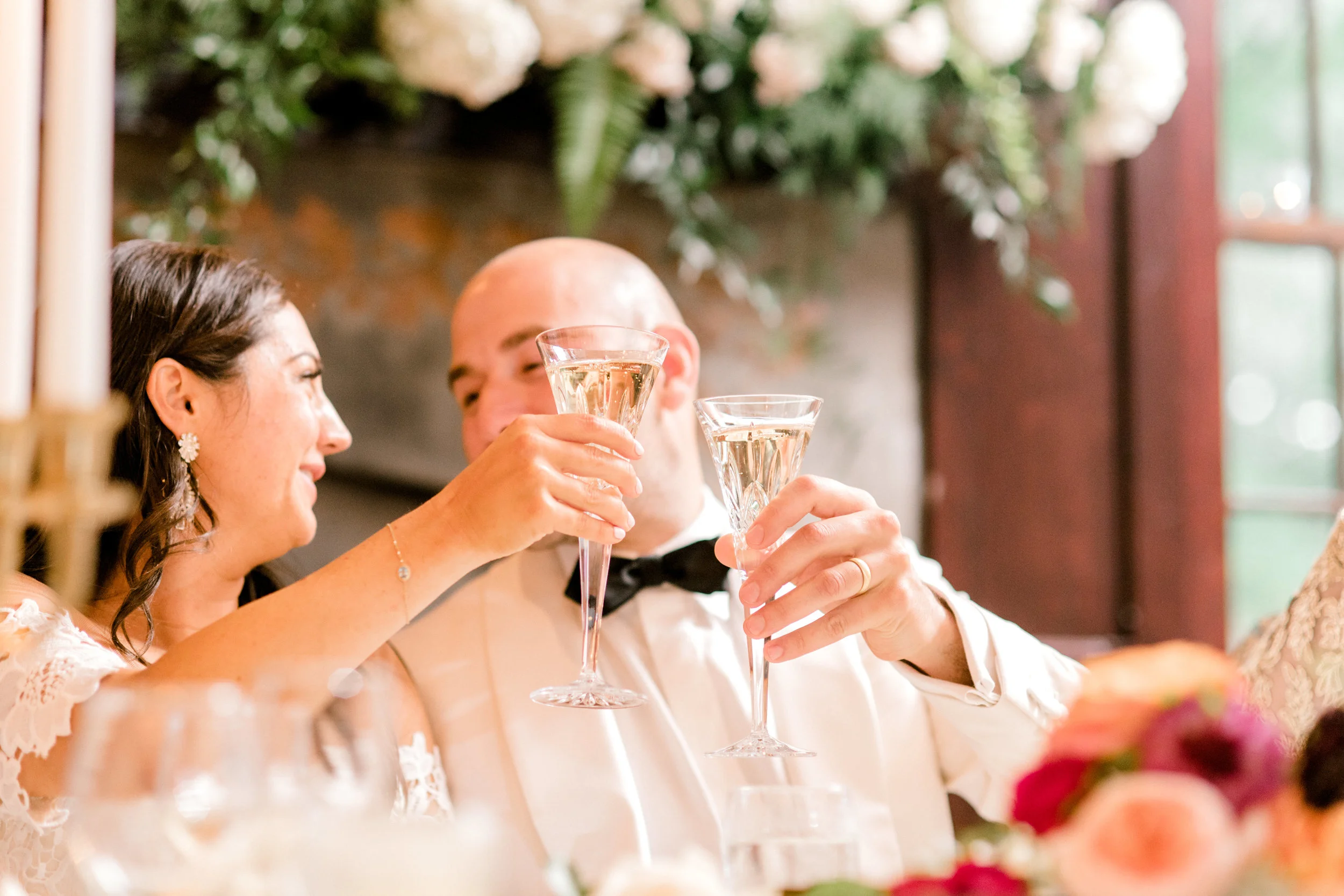 Cheers to the happy couple as they clink glasses at their modern elegant summer wedding at Hotel du Village.