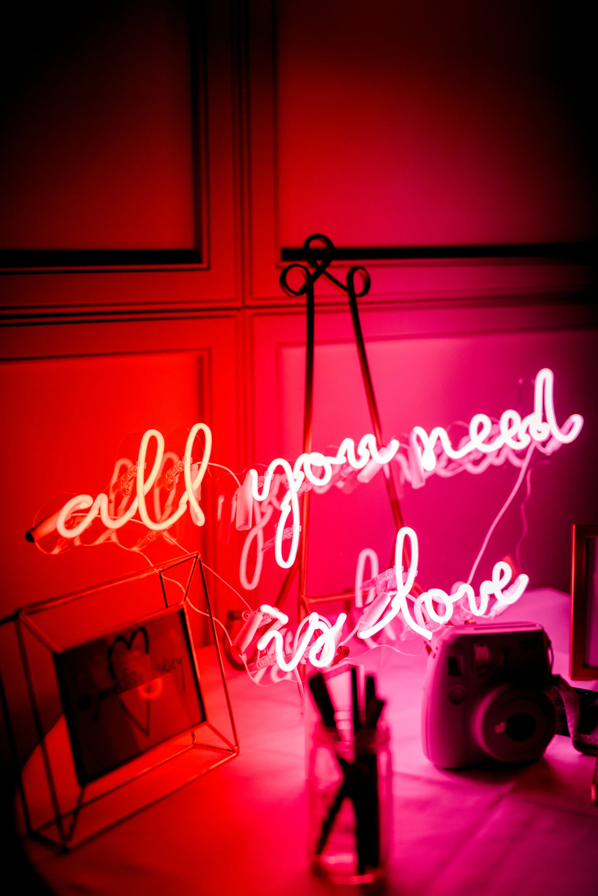 A pink and red neon sign adds a bright pop to this modern summer wedding at Hotel du Village.