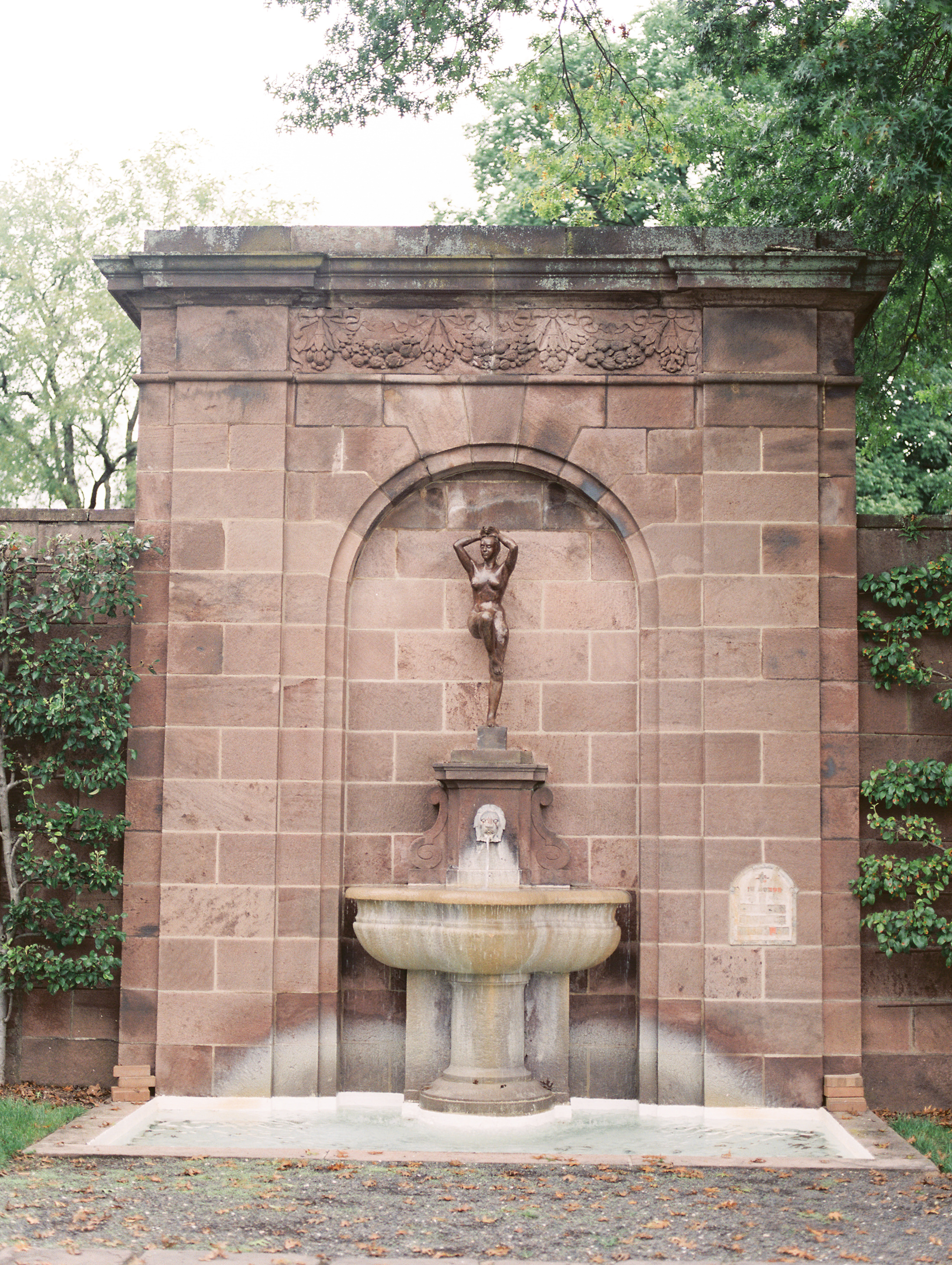 We love the french garden feeling of these inset statues framed by brick arches from this bright boho chic Tyler Gardens wedding in Bucks County