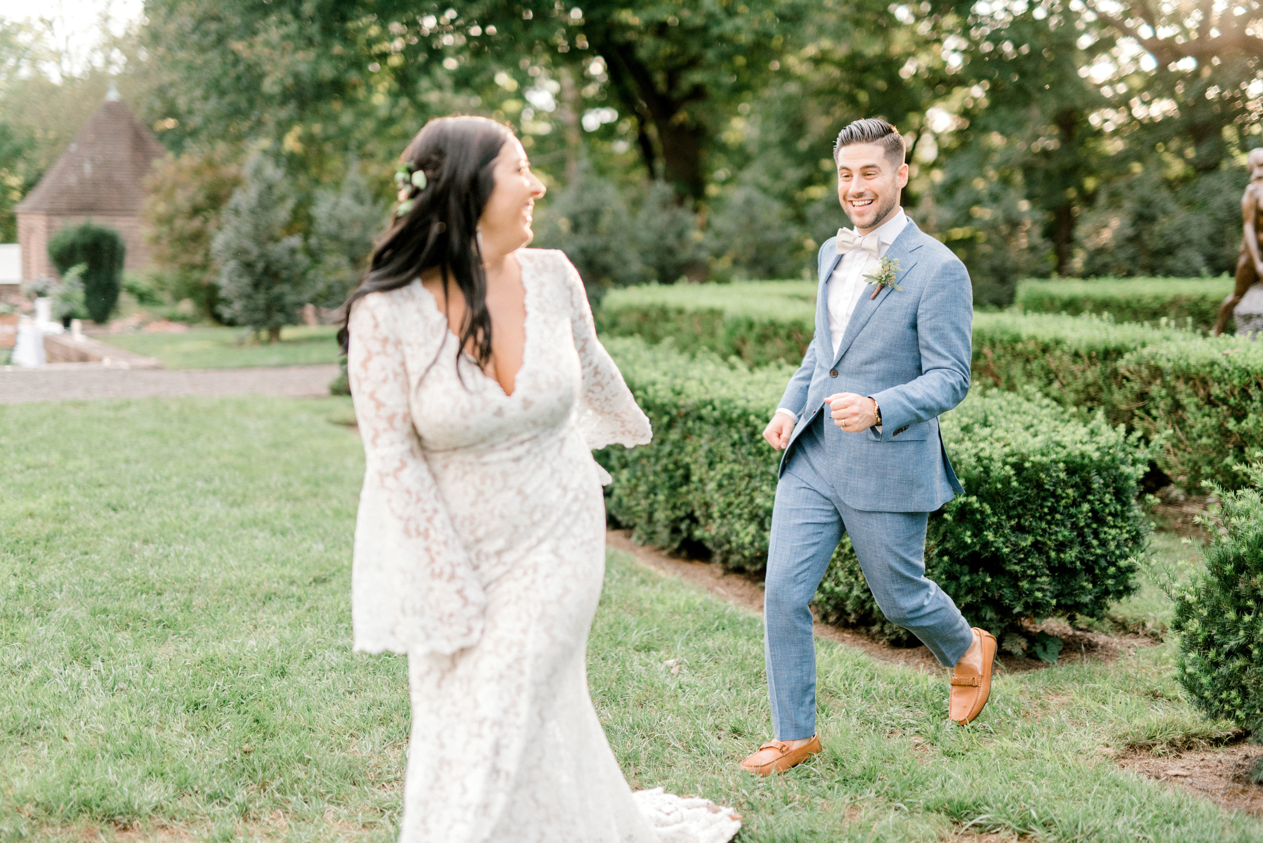Chasing each other in style through the garden, we loved Alicia’s bell sleeved lace dress paired with Mike’s light blue suit for this bright boho chic Tyler Gardens wedding in Bucks County