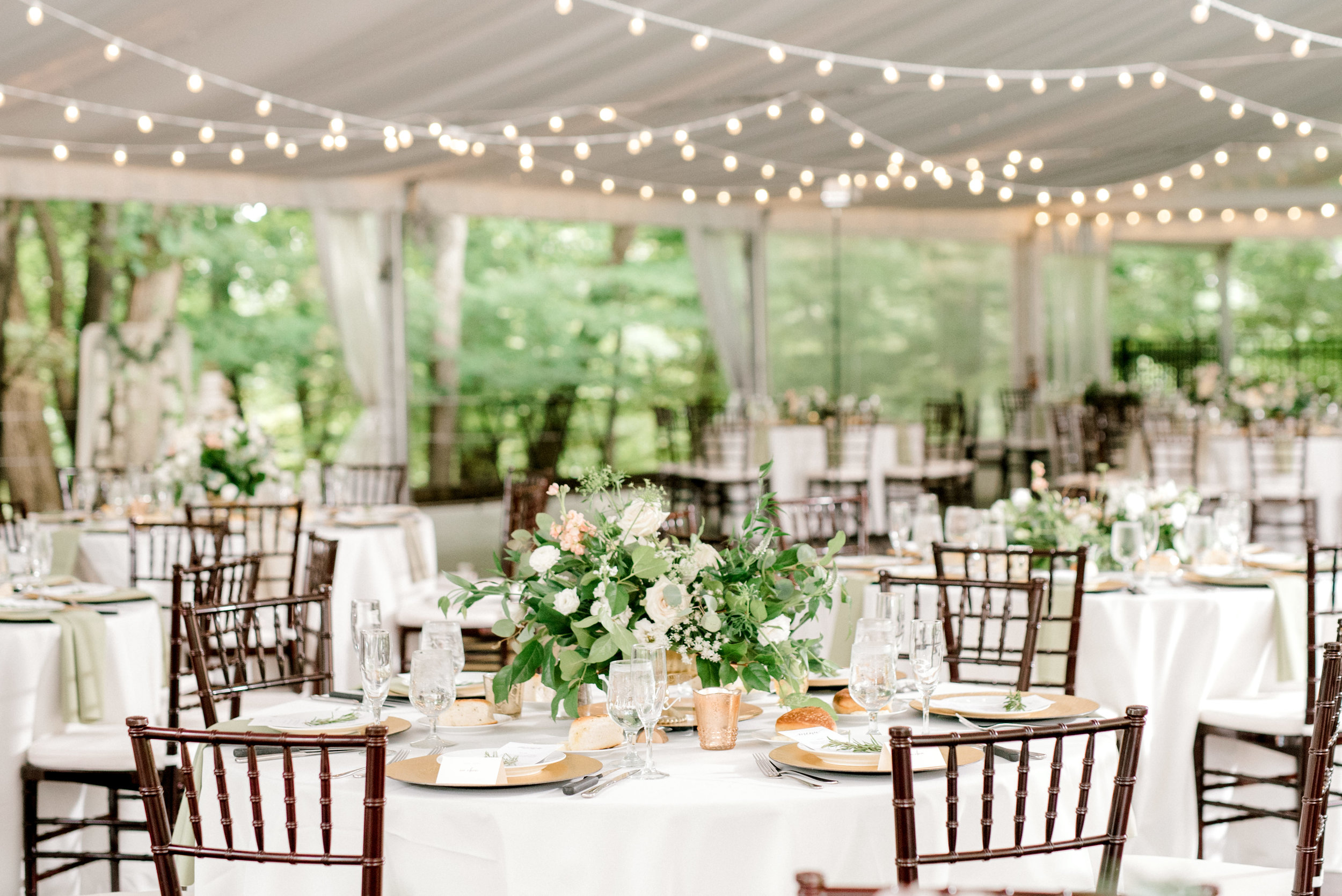 Classic whites and greens with a bit of whimsy in string lights pulled together the reception tent for this bright boho chic Tyler Gardens wedding in Bucks County.