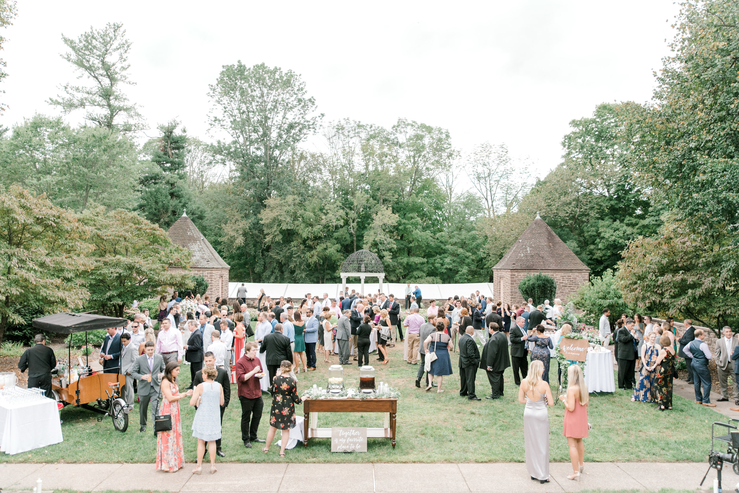 All gathered together in the garden, this cocktail hour brings right into an Italian style garden from this bright boho chic Tyler Gardens wedding in Bucks County