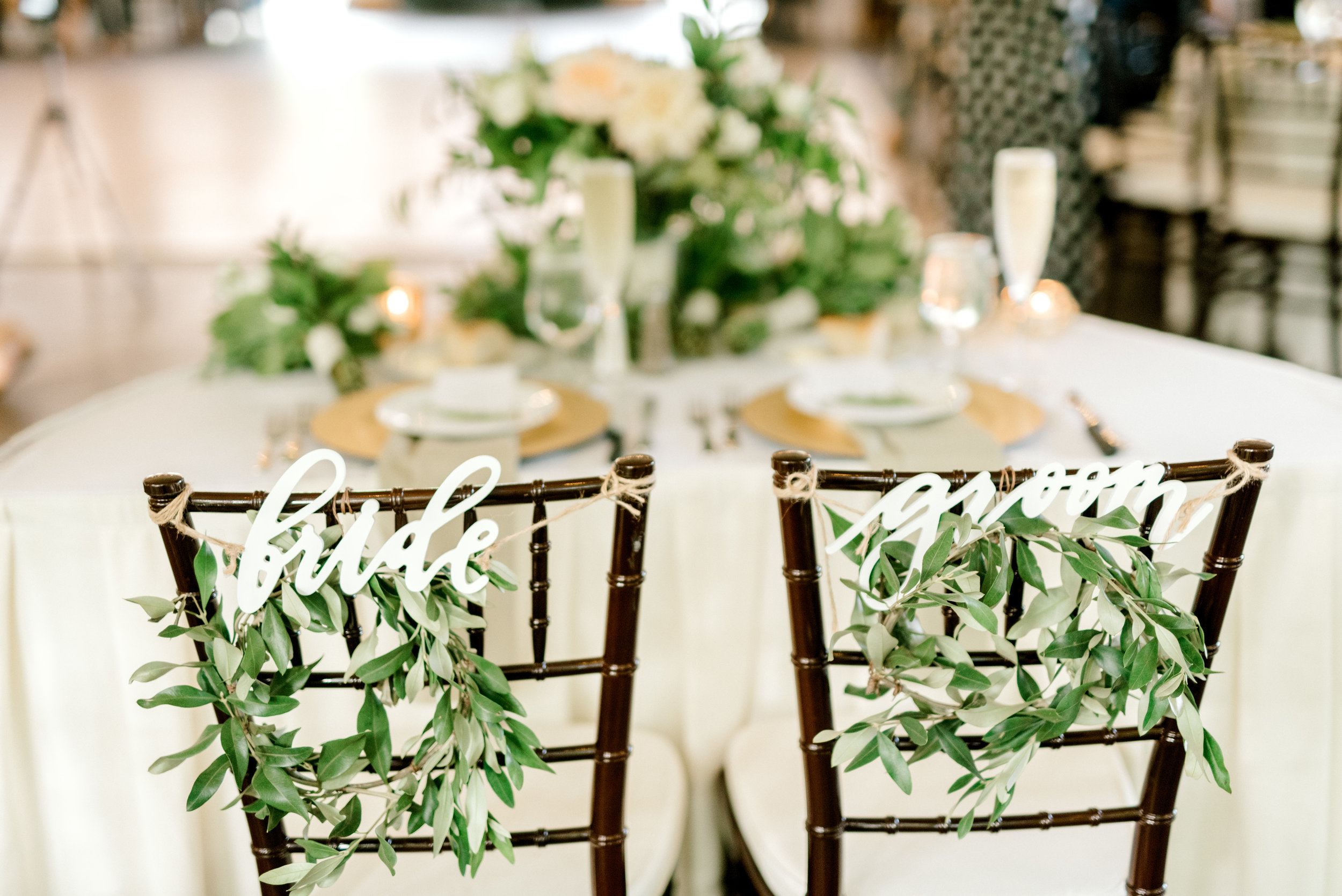 little green wreaths with laser cut signs identify the sweetheart table for this bright boho chic Tyler Gardens wedding in Bucks County
