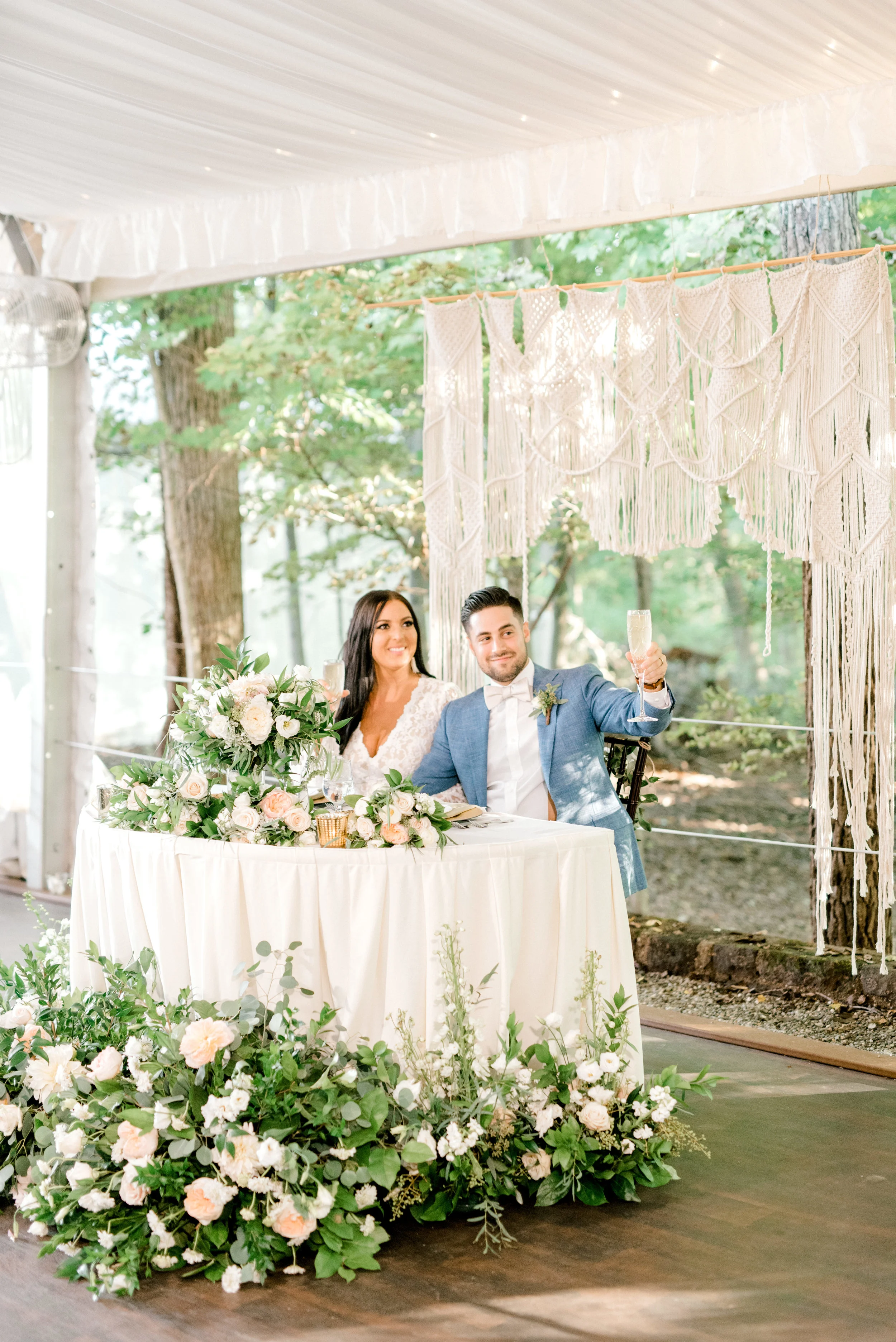 We loved this wild sweetheart table surrounded in whimsical greenery and given a white macrame backdrop from this bright boho chic Tyler Gardens wedding in Bucks County