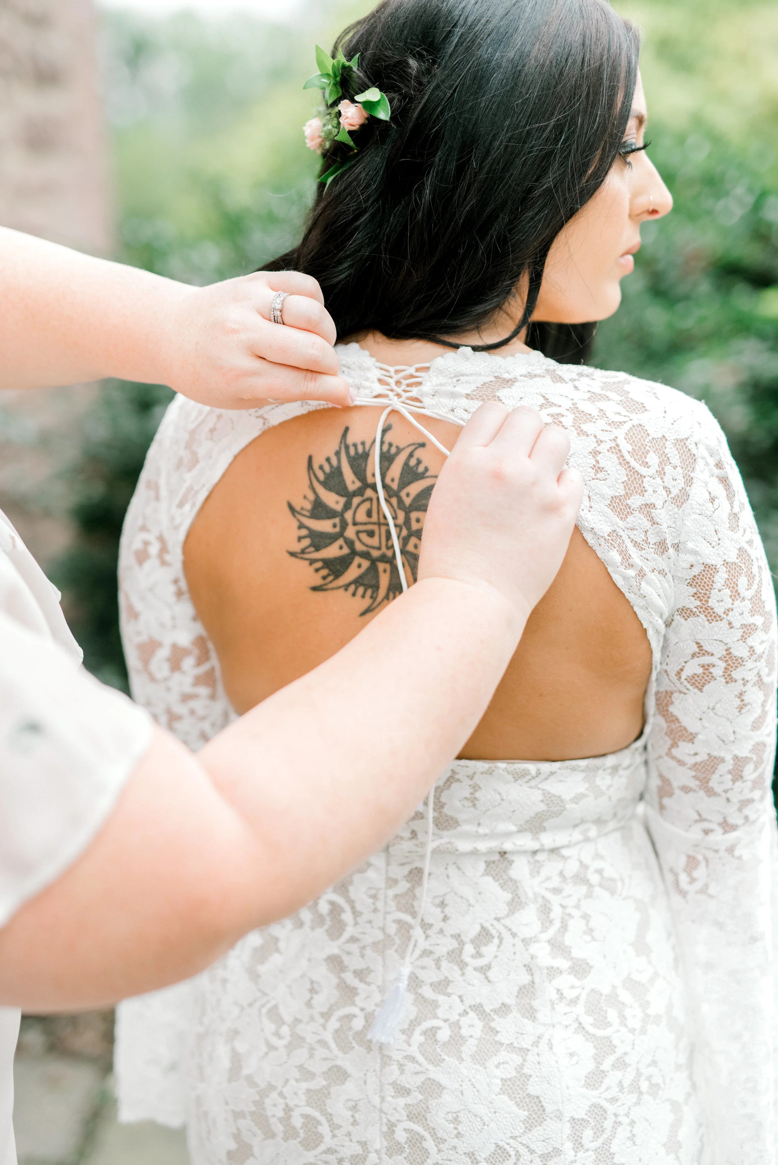 The finishing touches are added to Alicia’s dramatic lace BHLDN wedding gown just moments before entering her bright boho chic Tyler Gardens wedding in Bucks County