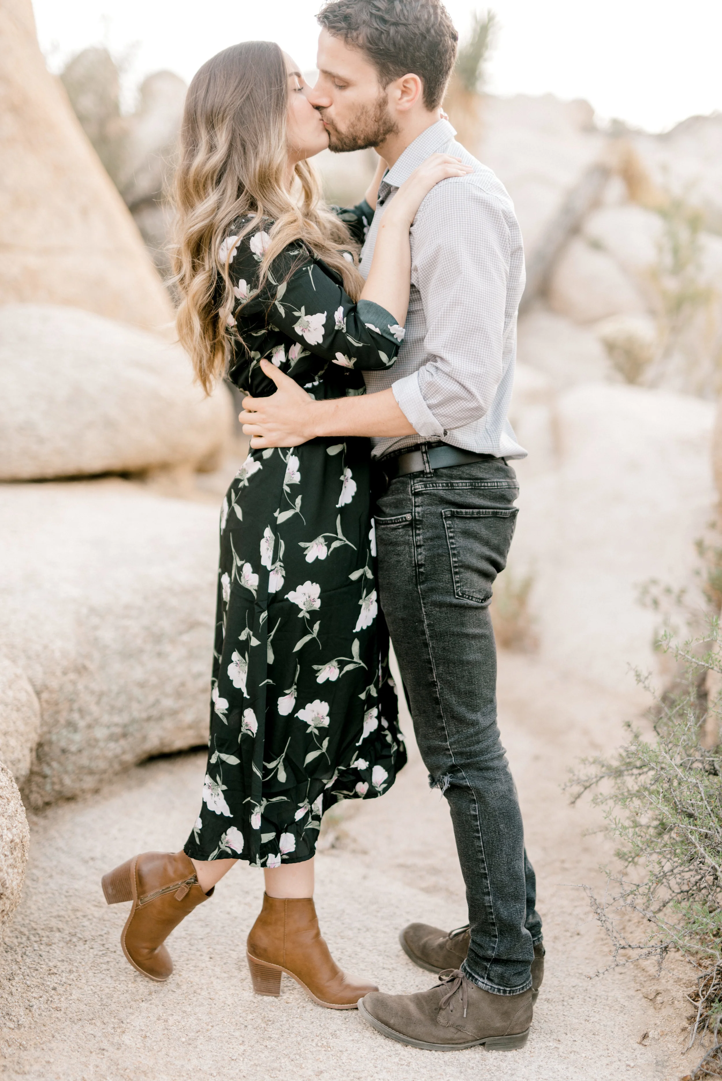 Smooches for this stylish boho couple at their free-spirited desert engagement session in Joshue Tree