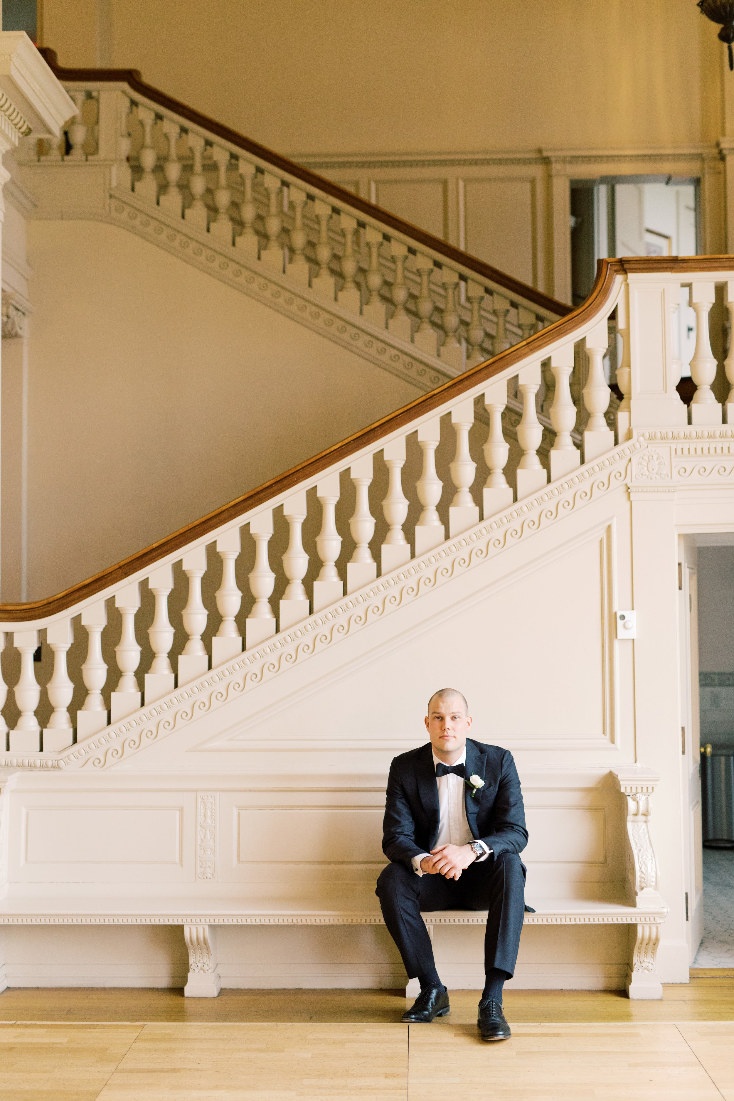 The grand staircase made for an impactful statement for portraits with this classic groom from this romantic and classic wedding day for their french inspired green and white Cairnwood Estate wedding