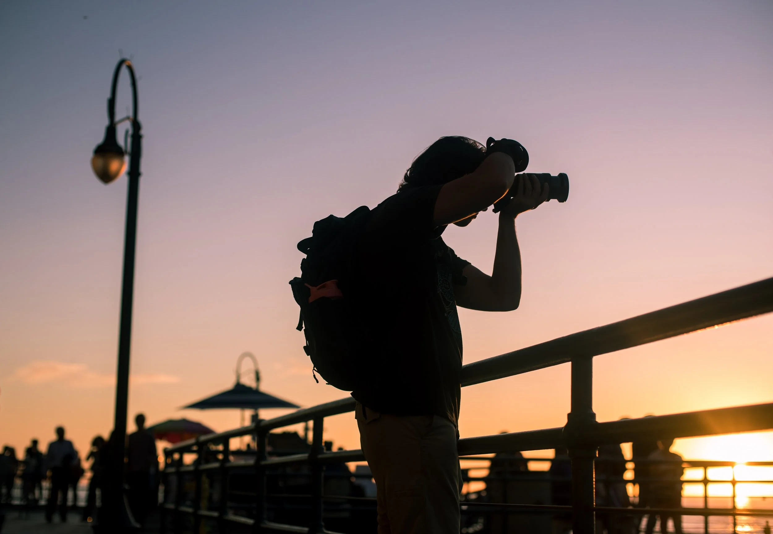 man with camera shooting sunset.jpeg