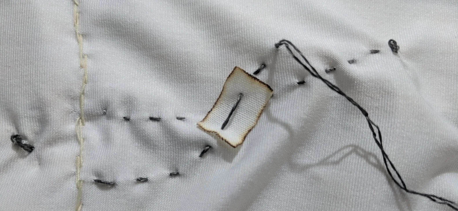 Cotton insulating patch to avoid short circuit between the two conductive threads