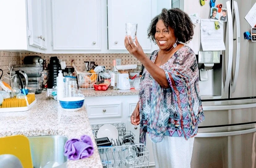 Cheryl Abrams is inspecting a glass from a postpartum client's dishwasher