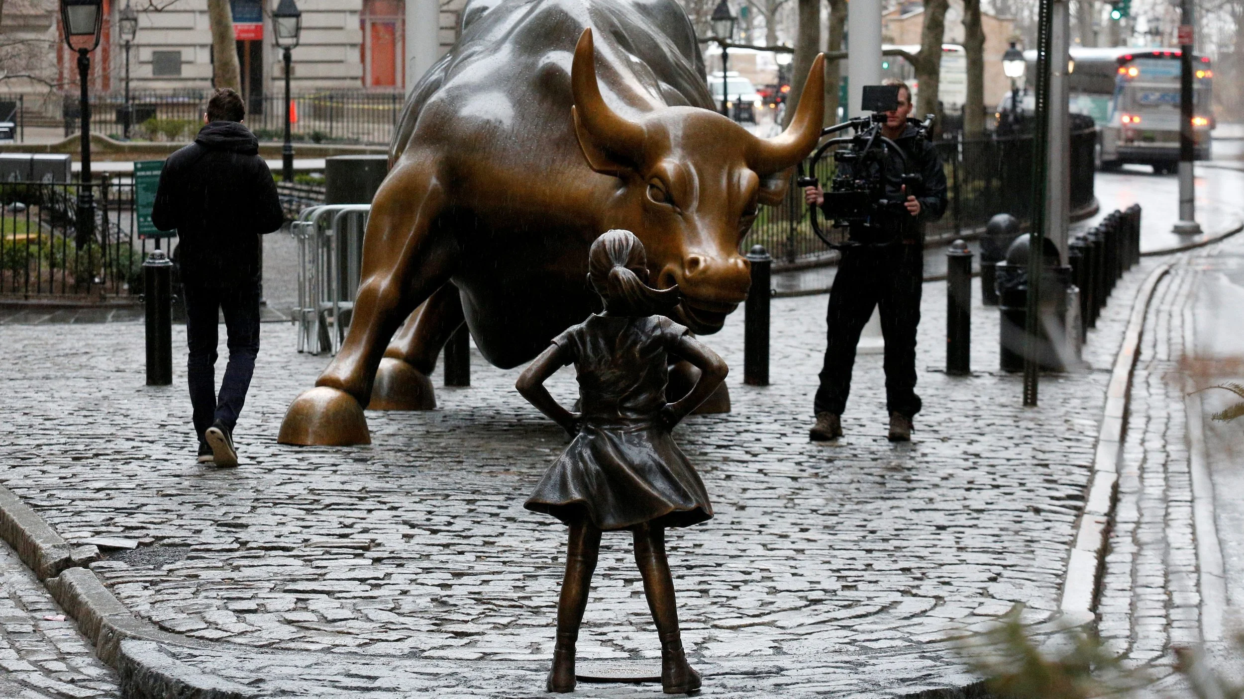 The veteran of Wall St, the Charging Bull being stared down by a newcomer - the Fearless Girl, photo from Quartz
