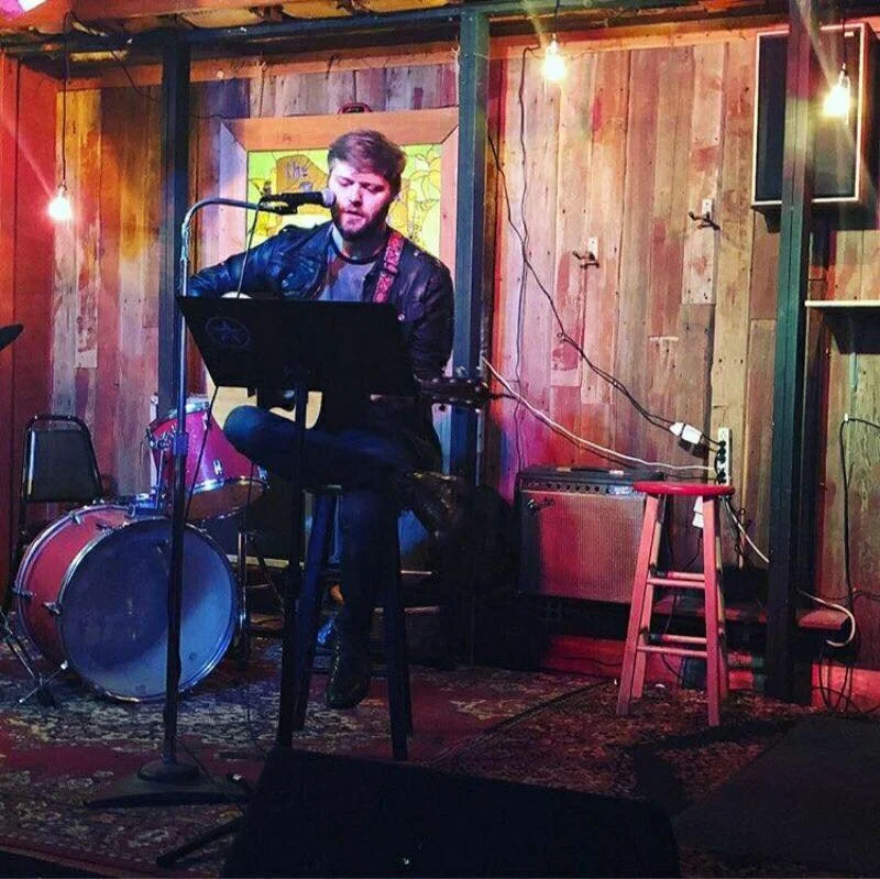 JD Greving - 1:30PM JD Greving is a singer-songwriter from Central IL, he has written over 300 songs and has released 7 albums under the pseudonym Memorial For a Dove. Greving’s lyrics are sharp and witty ranging from simpler concepts of love and politics, to deeper concepts of loss and acceptance. You can be laughing at one line and have your reality shattered in the next. Bottom line, Greving’s aim is a little more focused on changing who his listeners are and their perceptions of who they can be, and refuses to enable stagnation.