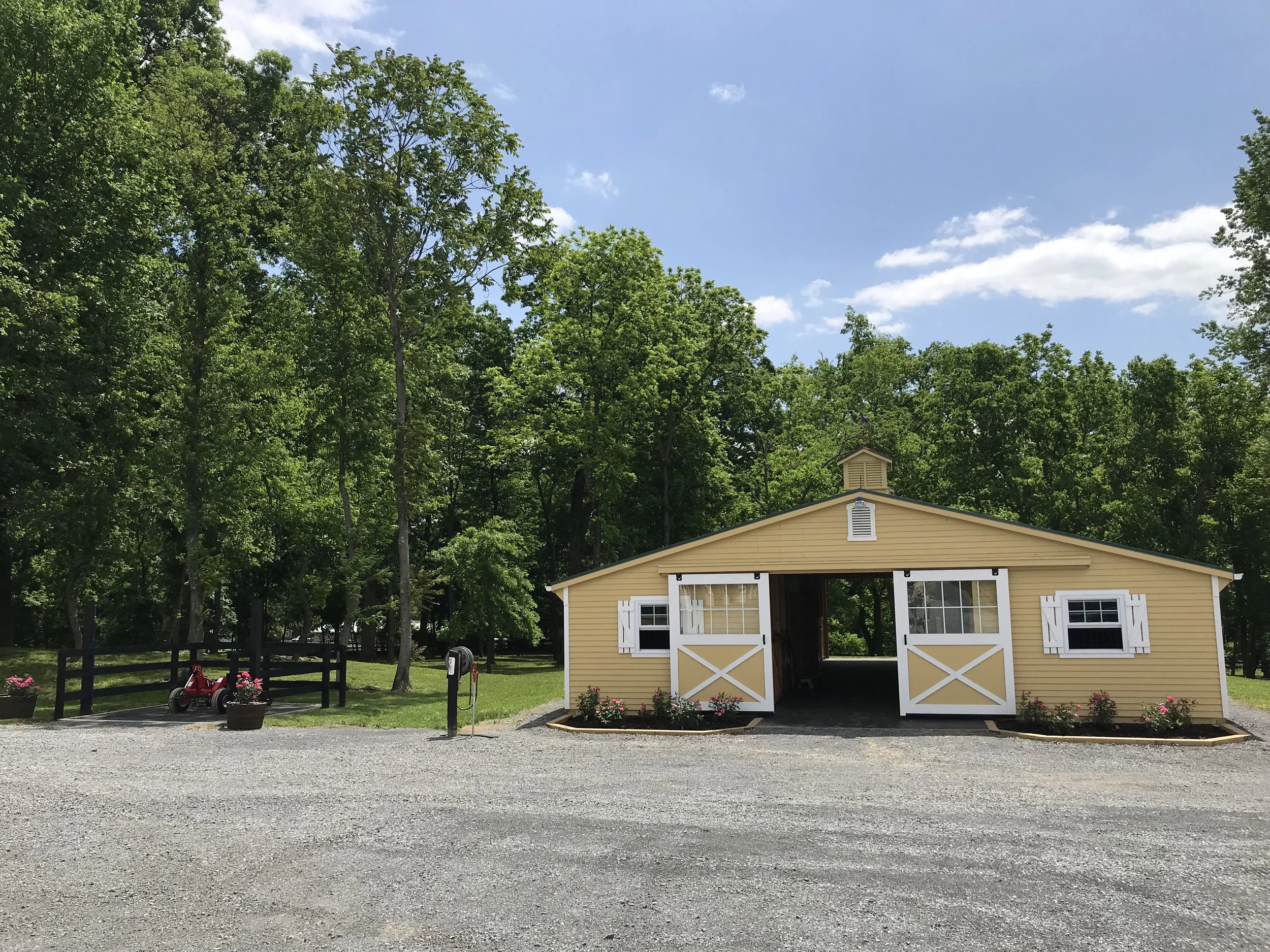 Our lower barn, also known as our guest barn, has 7 stalls and a tack room. Each rider has a saddle rack and bridal hooks. Every stall has a window and a fan. A generous breezeway keeps the air moving during hot summer months. Next to the barn is a wash stall where you can rinse your horse after your ride. 