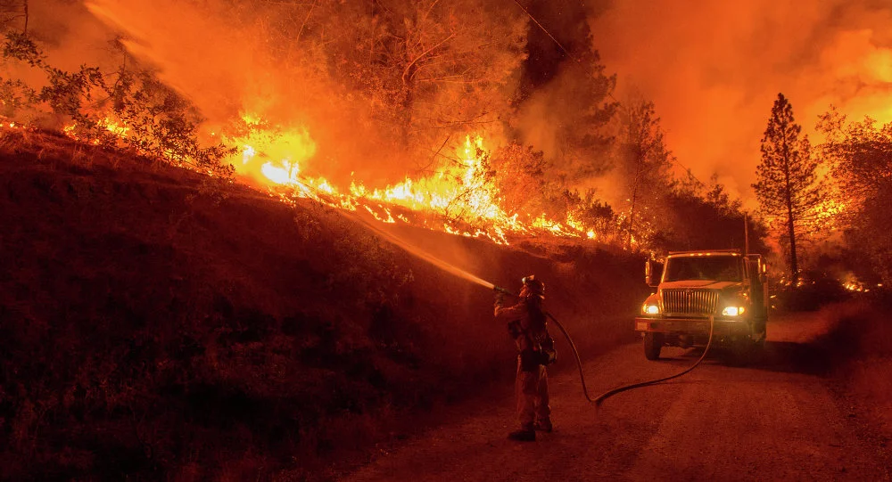A firefighter douses flames from a backfire while battling the Butte fire in 2015 (Josh Edelson)