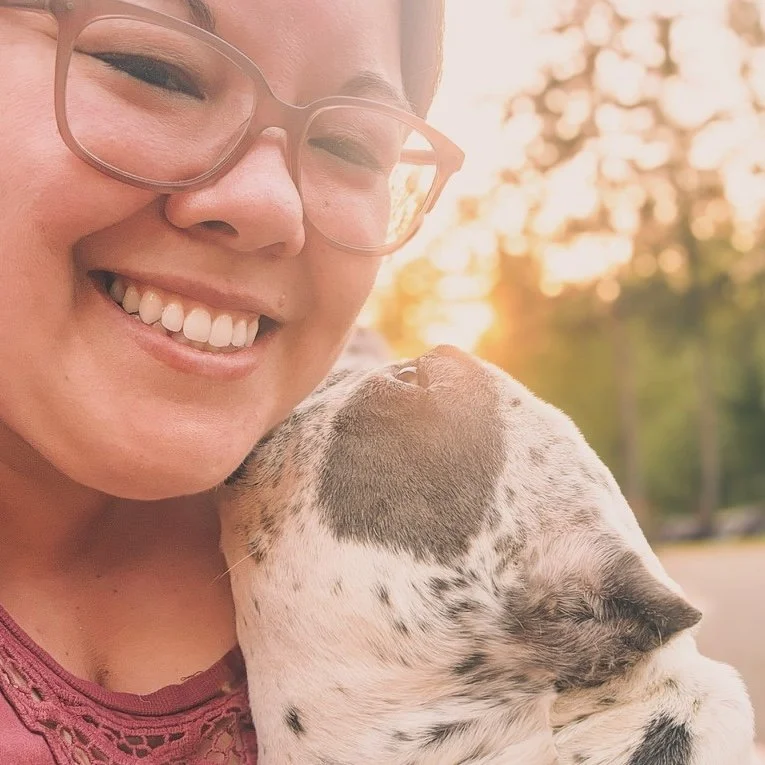 Tabbi, Office Manager at Port Orchard Animal Clinic in Port Orchard, Washington, smiling with her dog.