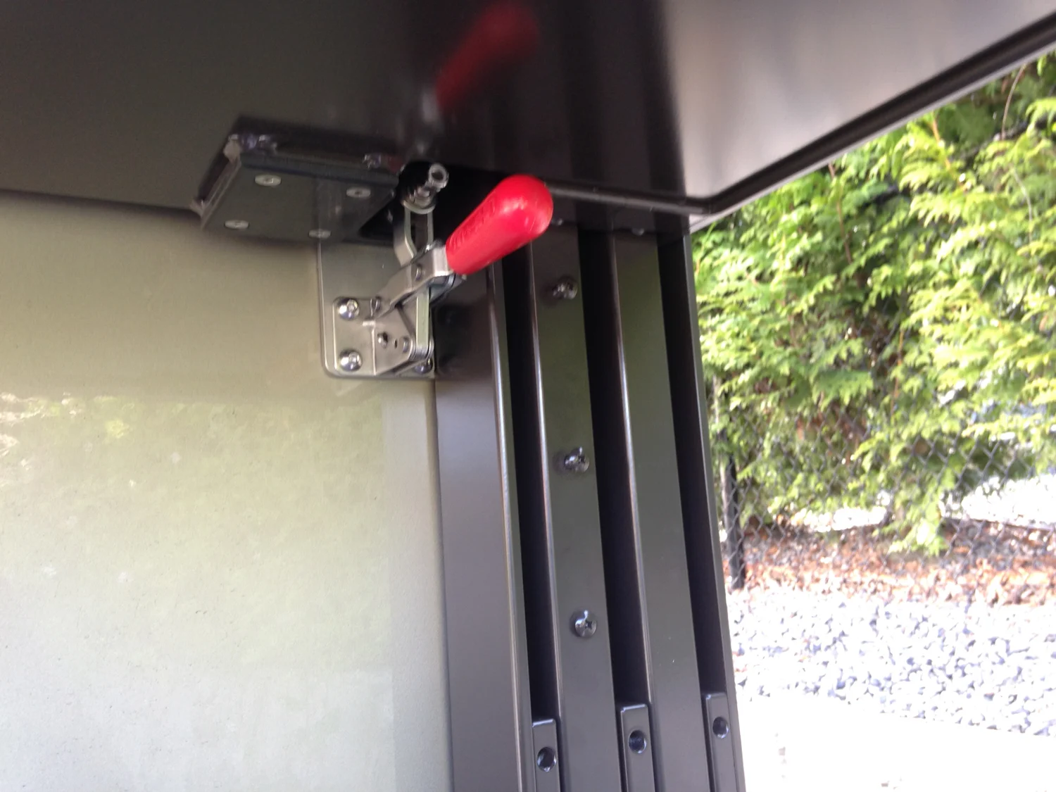The red handle is the safety lock that prevents the lift from falling if the cable or hoist fails.