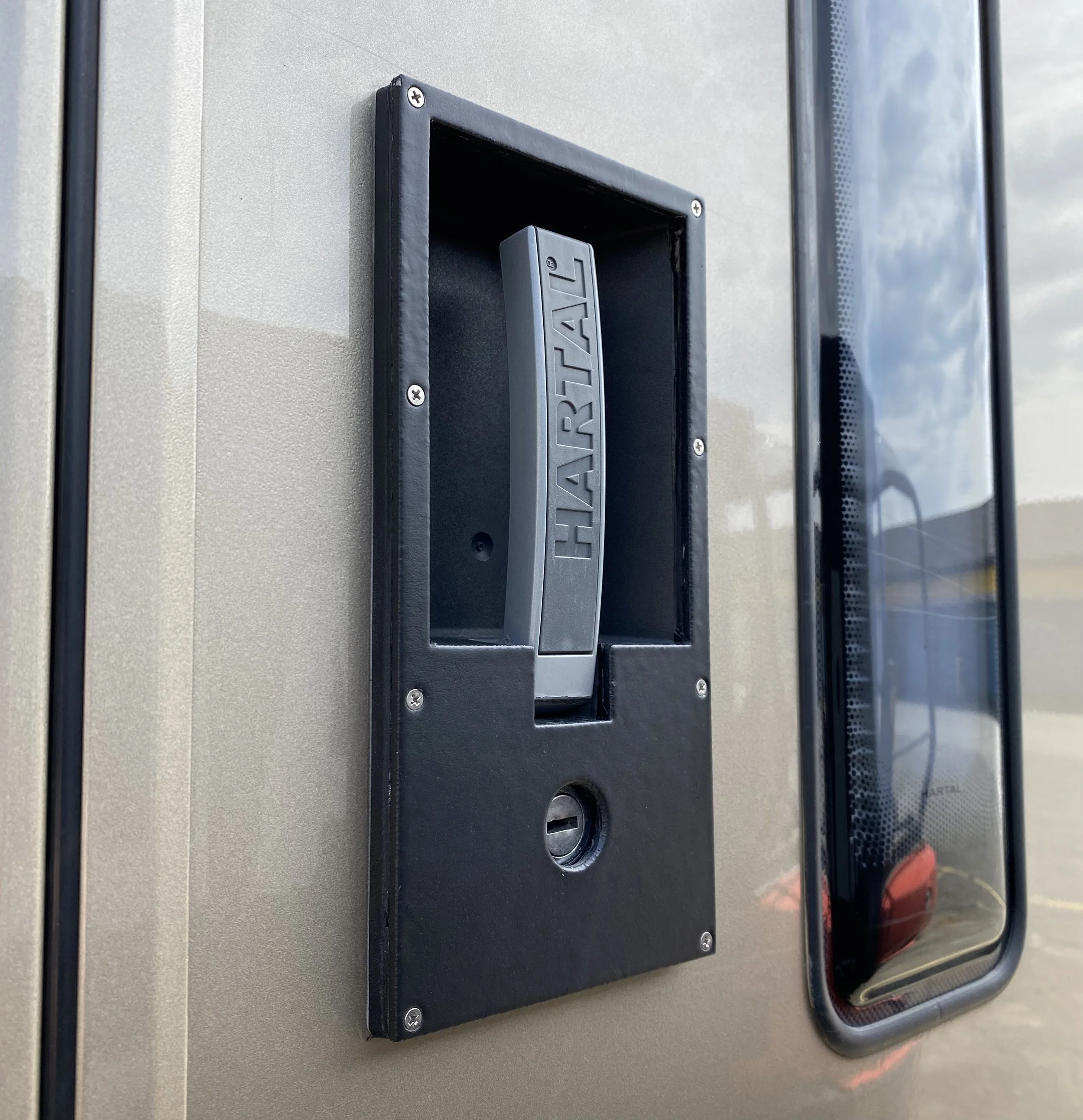  The door opener that needs repair, and which was previously repaired because of a crack in the outer facia. I made this new facia from aluminum and glued and screwed it over the factory plastic panel. 