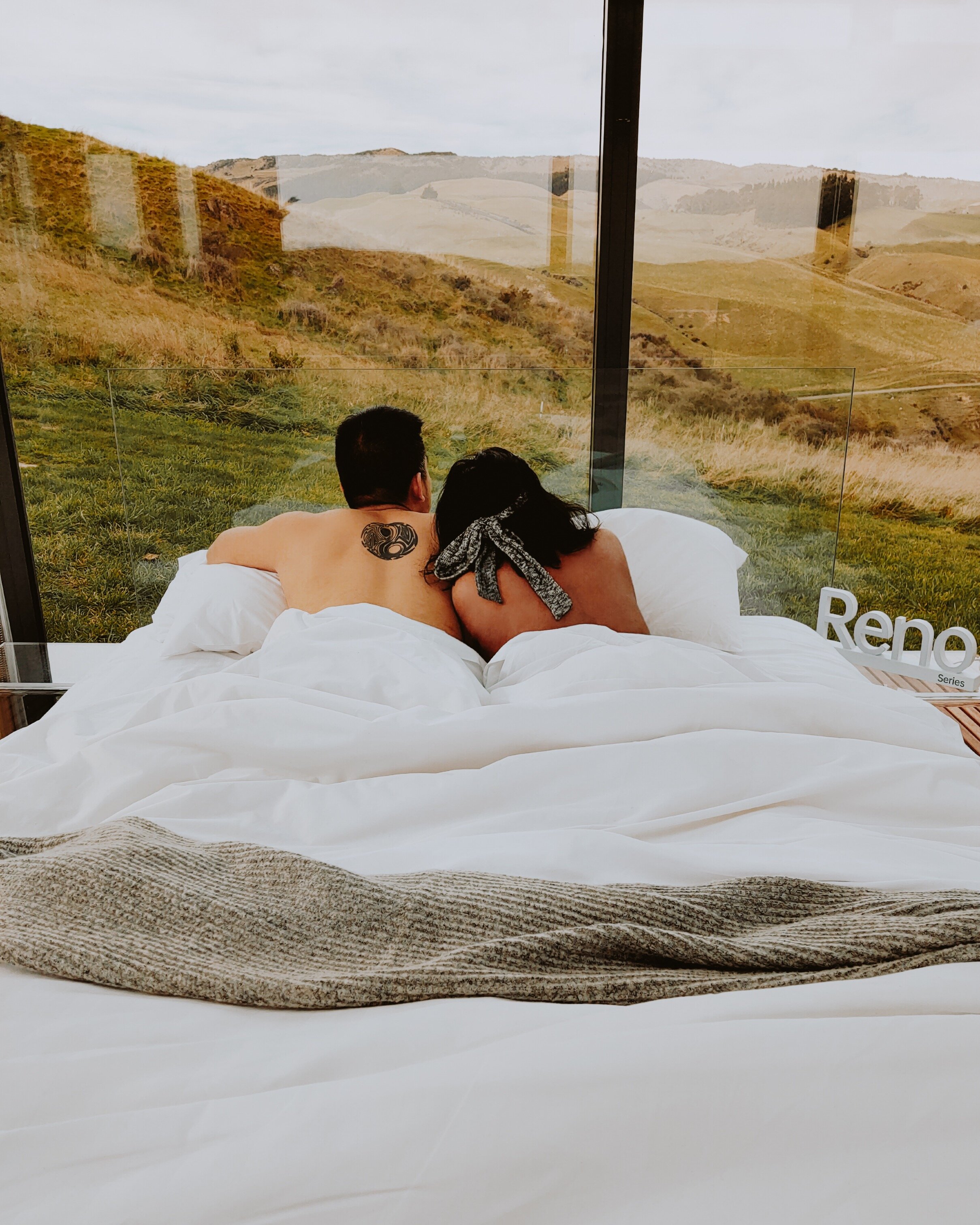 aucklands-best-weekend-getaways-oppo-reno-wairapa-pure-pod-glass-house-couple-in-bed