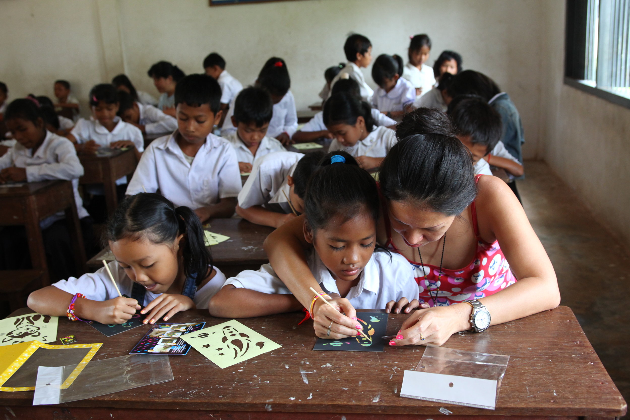 Teacher assisting students at Colors of Cambodia