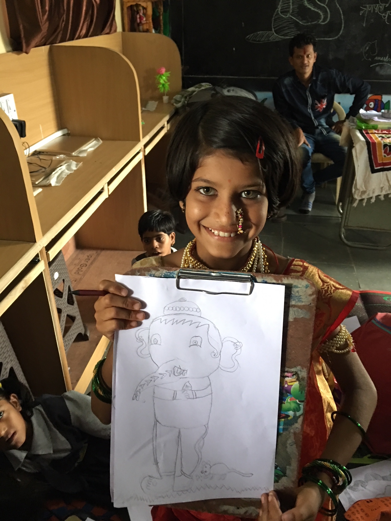 Student artist displaying elephant drawing (Maharashtra, India)