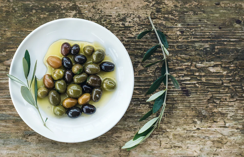 plate-of-mediterranean-olives-in-oil-with-tree-PD3FXRN.jpg