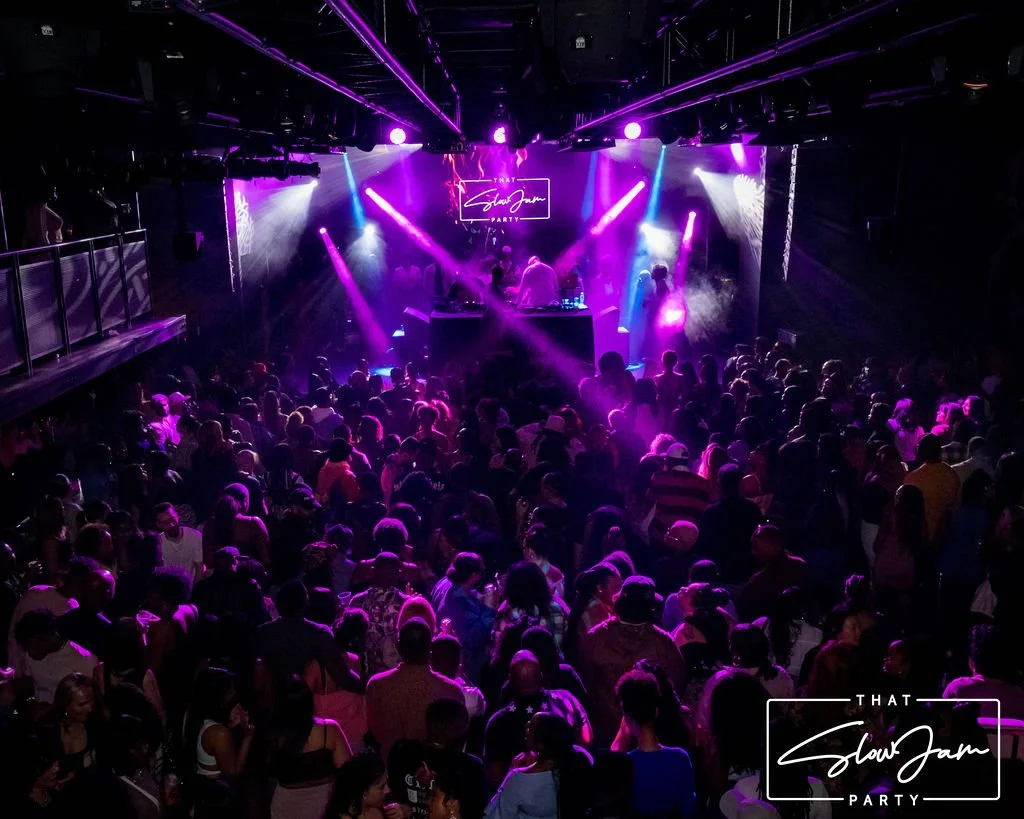 A packed dance floor at That Slow Jam Party, featuring a live DJ set under purple stage lighting as a stylish crowd enjoys an immersive R&B nightlife experience designed for grown and sexy music lovers.