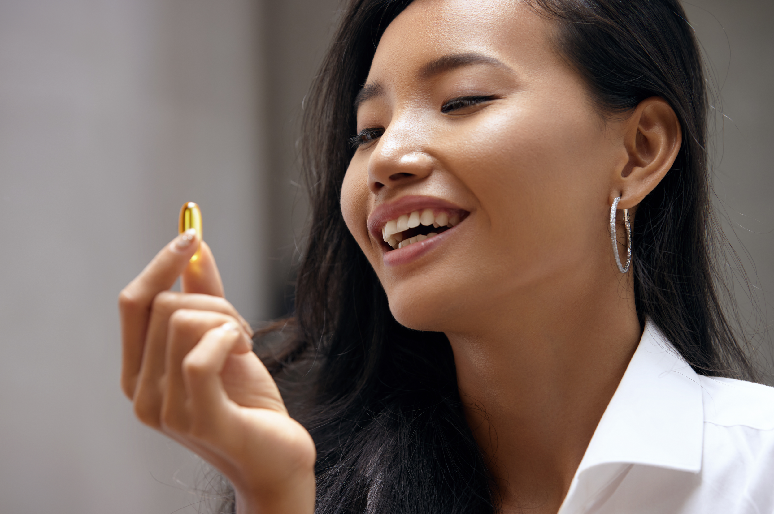 Imega showing young woman with an omega-3 DHA supplement