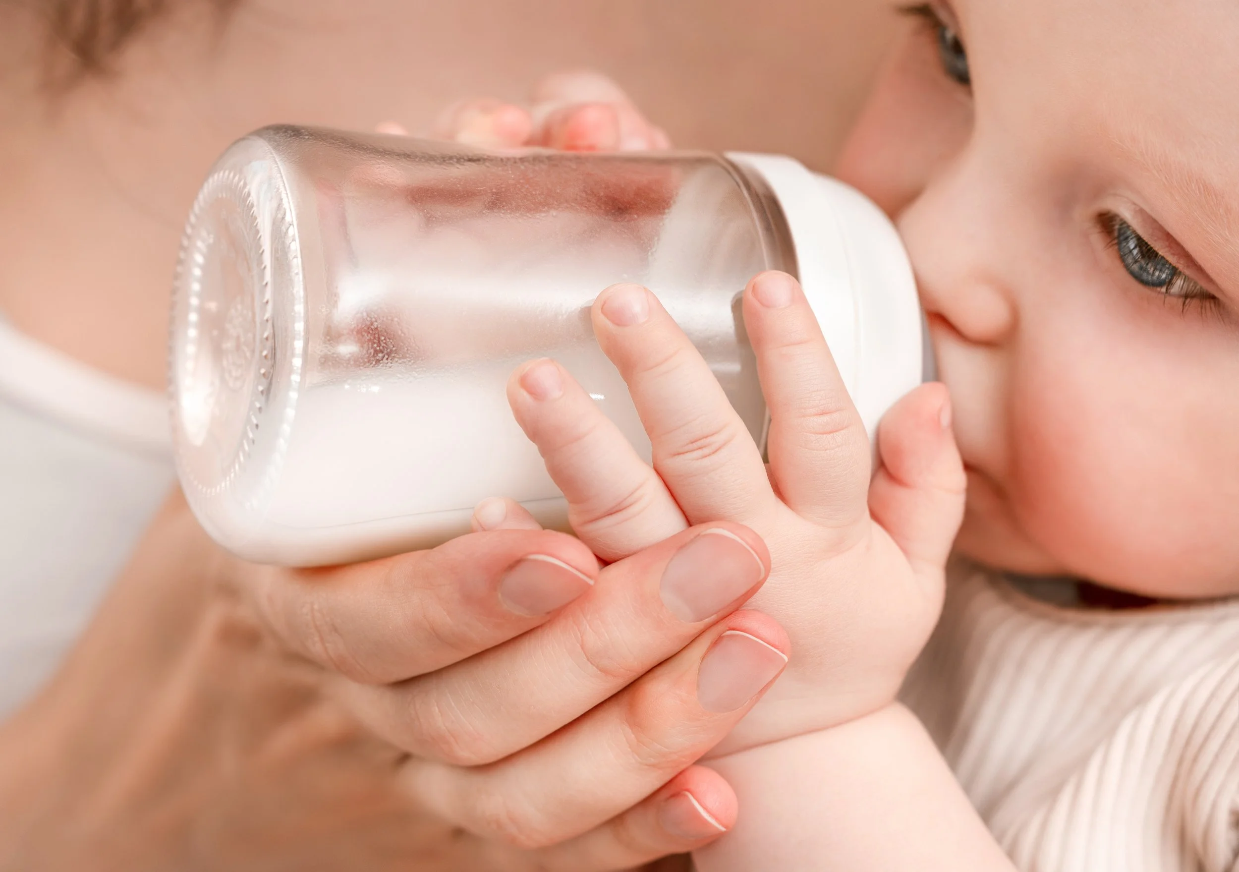 Baby drinking from bottle of infant formula containing omega-3 DHA